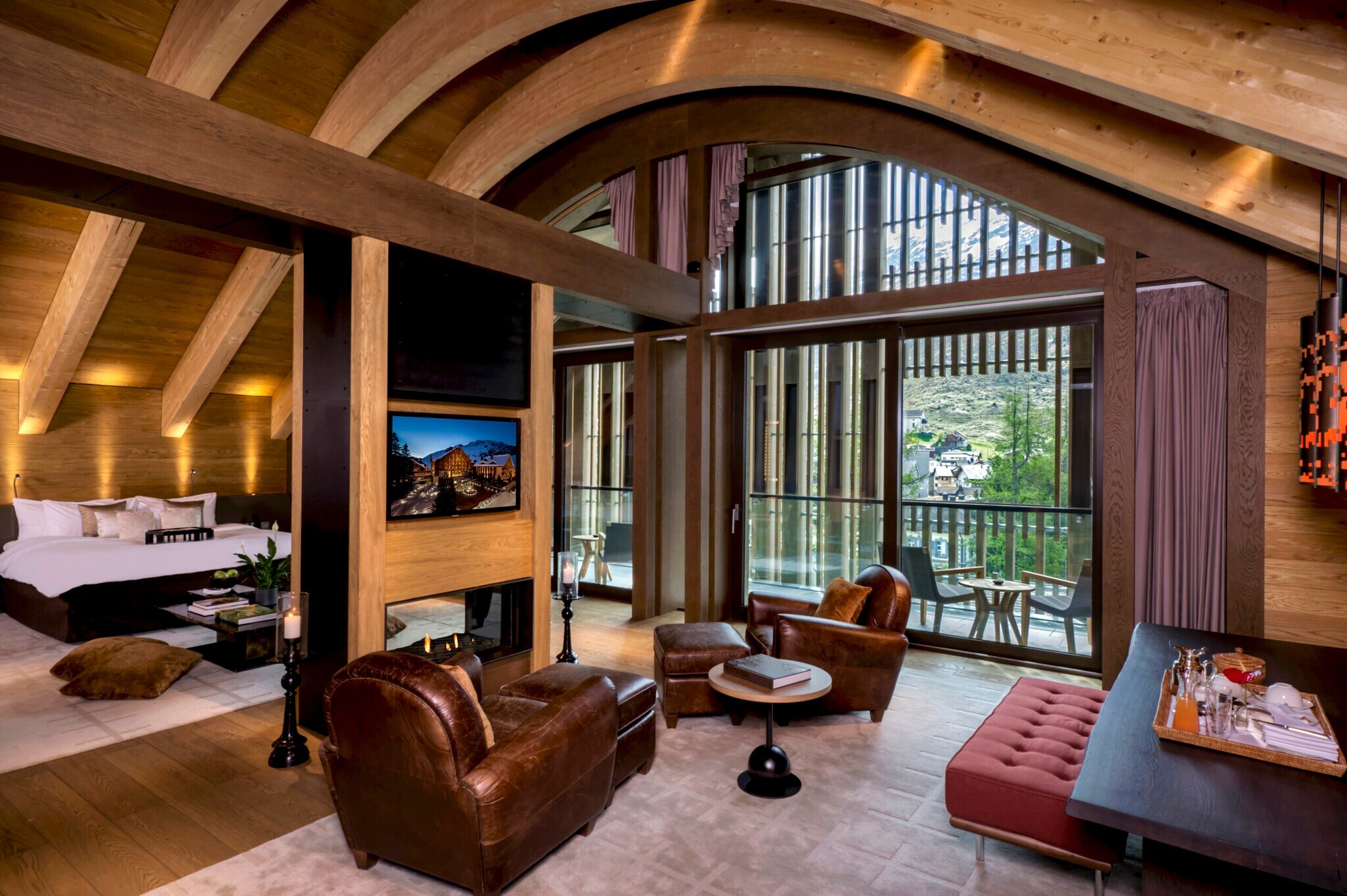Innenraumaufnahme einer modernen Hotelsuite mit Terrasse und Blick in die Berge Innenraumaufnahme einer modernen Hotelsuite mit Terrasse und Blick in die Berge