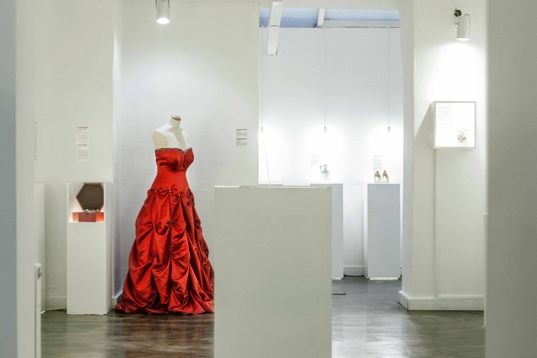 Ein rotes Abendkleid auf einer Schneiderpuppe in einem weißen Showroom