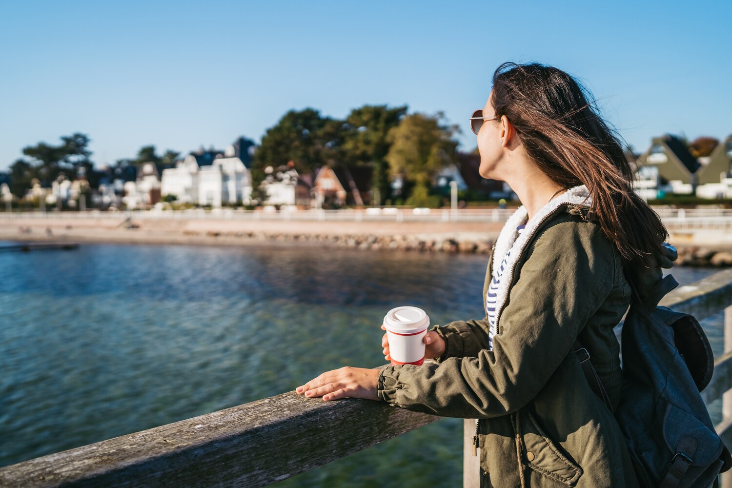 Eine junge Frau steht auf einer Seebrücke