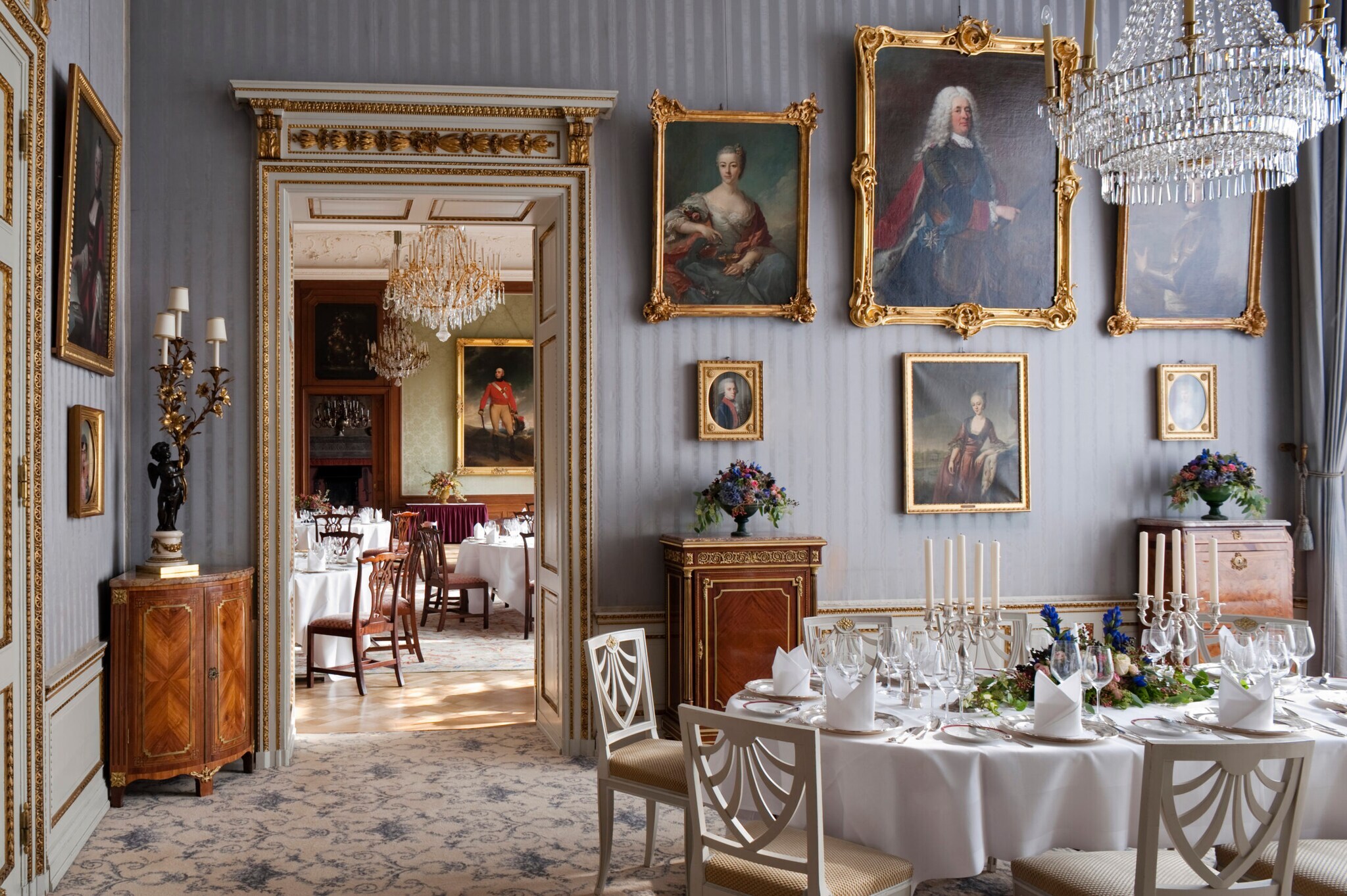 Prunkvoller Salon mit gedeckten Tischen und Ölgemälden an der Wand Prunkvoller Salon mit gedeckten Tischen und Ölgemälden an der Wand