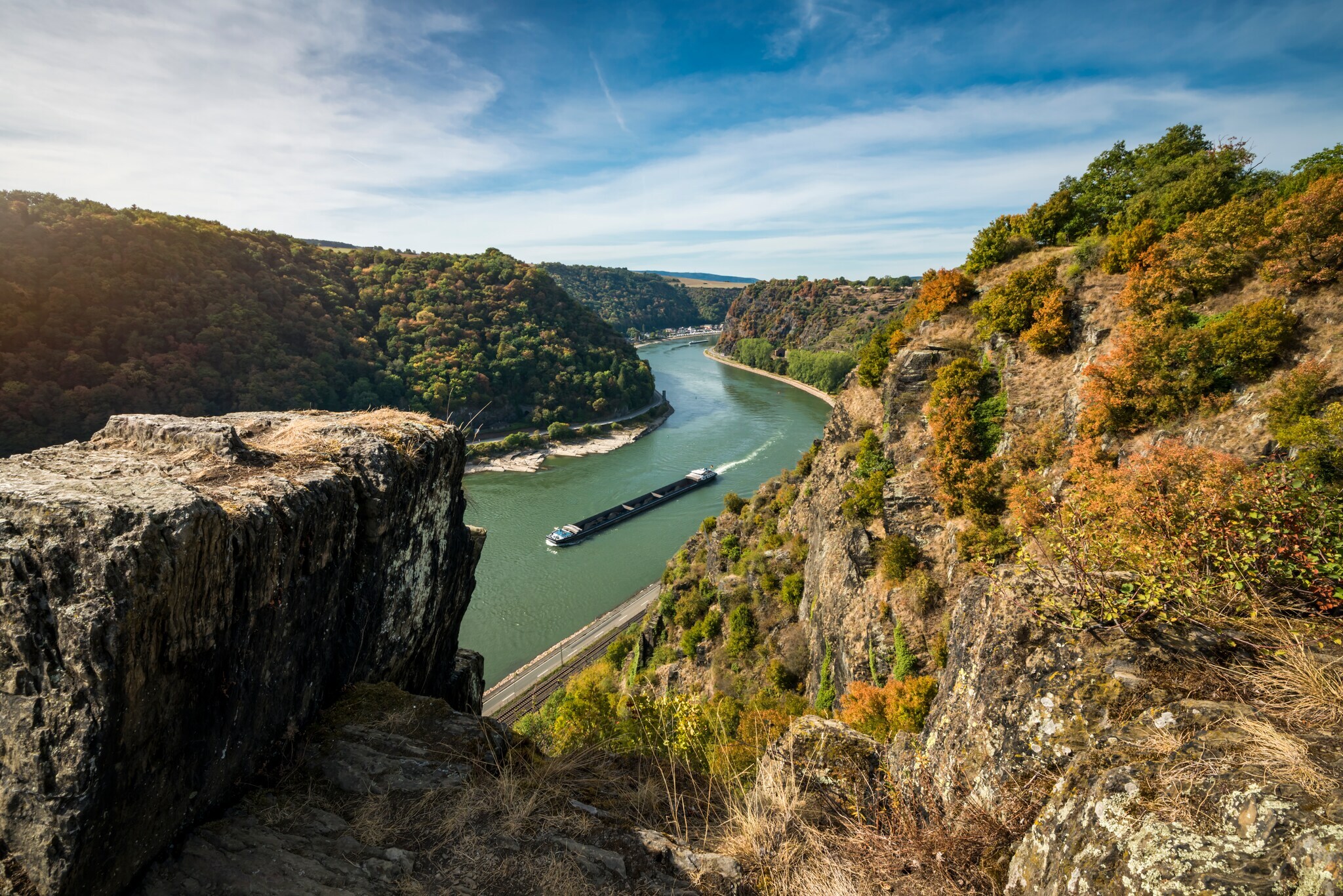 Panoramablick auf Rheinkurve mit Containerschiff von einem Plateau in felsiger Umgebung Panoramablick auf Rheinkurve mit Containerschiff von einem Plateau in felsiger Umgebung