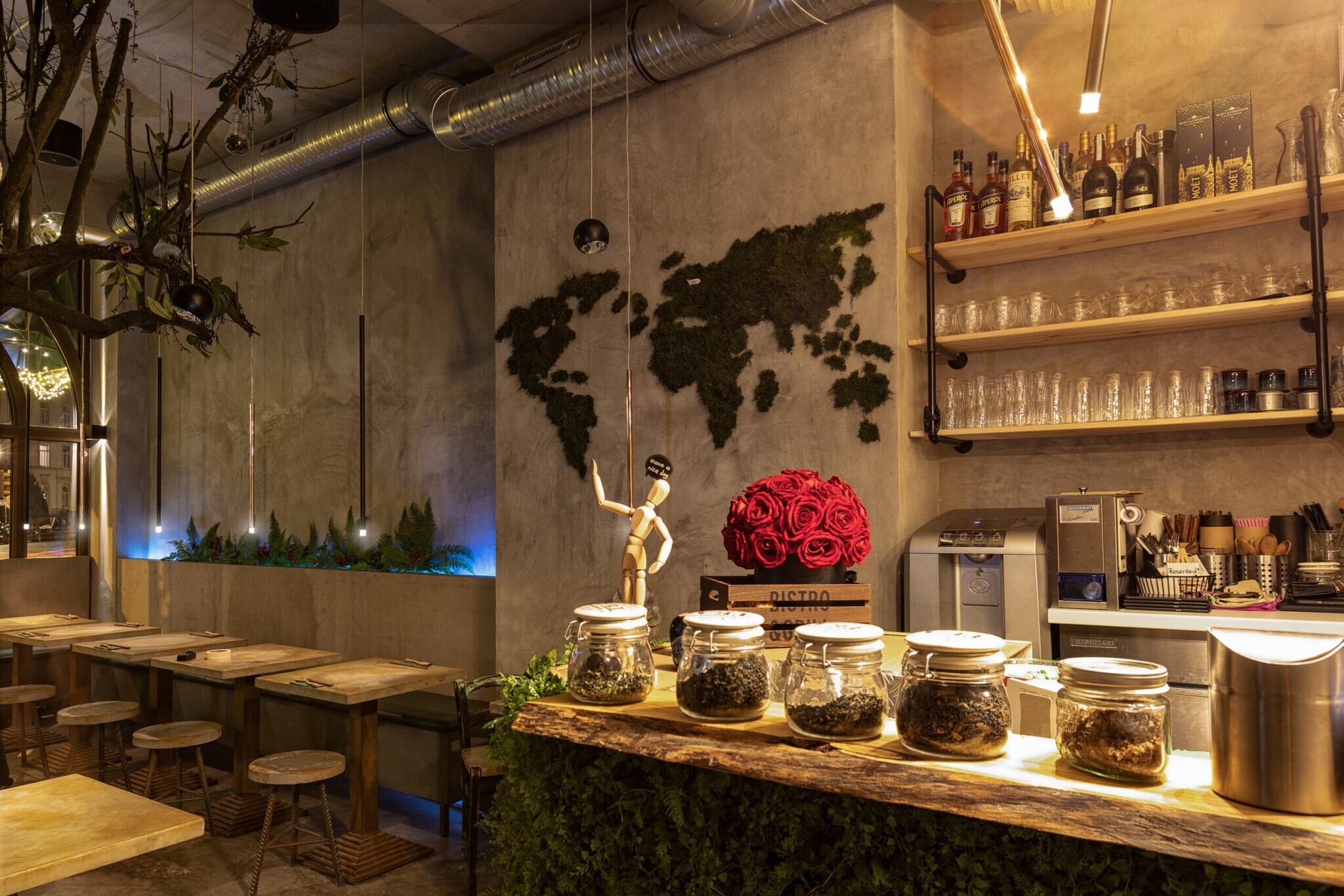 Innenraum eines modernen Restaurants mit Betonwänden, Holztheke und Pflanzen