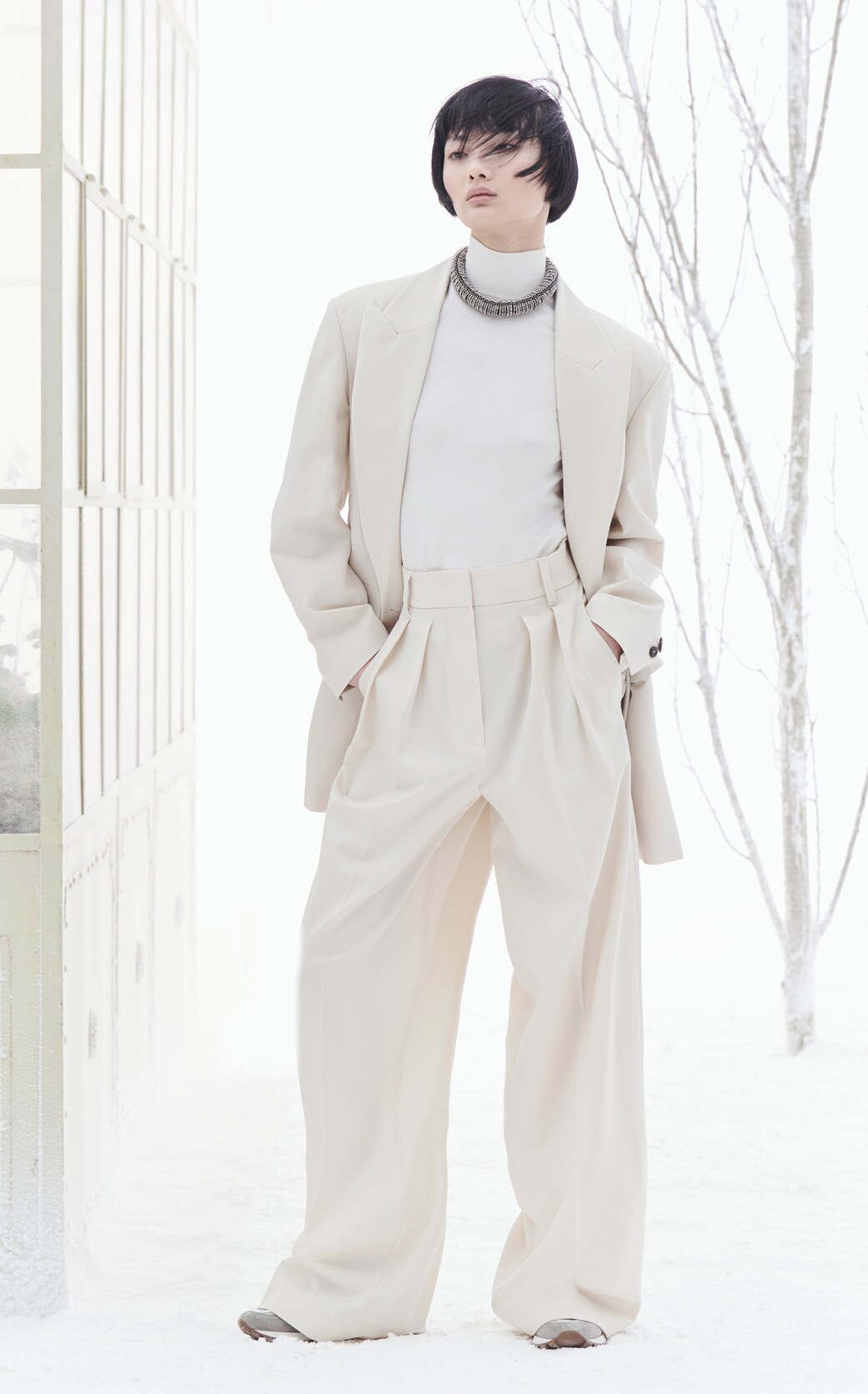 Ein Model trägt einen cremefarbenen Look von Brunello Cucinelli. Ein Model trägt einen cremefarbenen Look von Brunello Cucinelli.