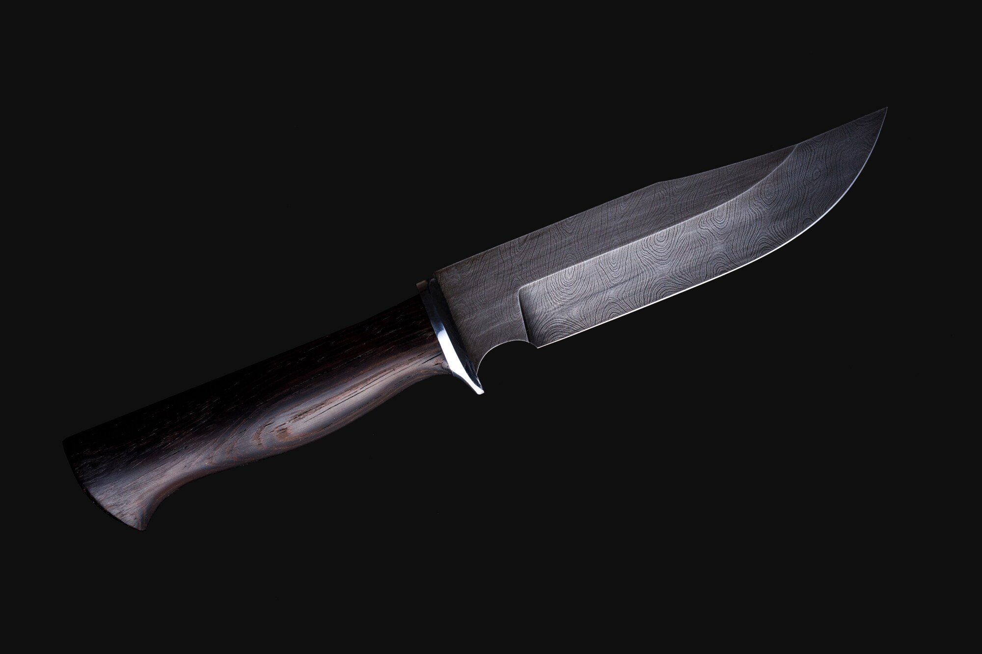 Ein Messer mit schwarzem Griff isoliert vor schwarzem Hintergrund