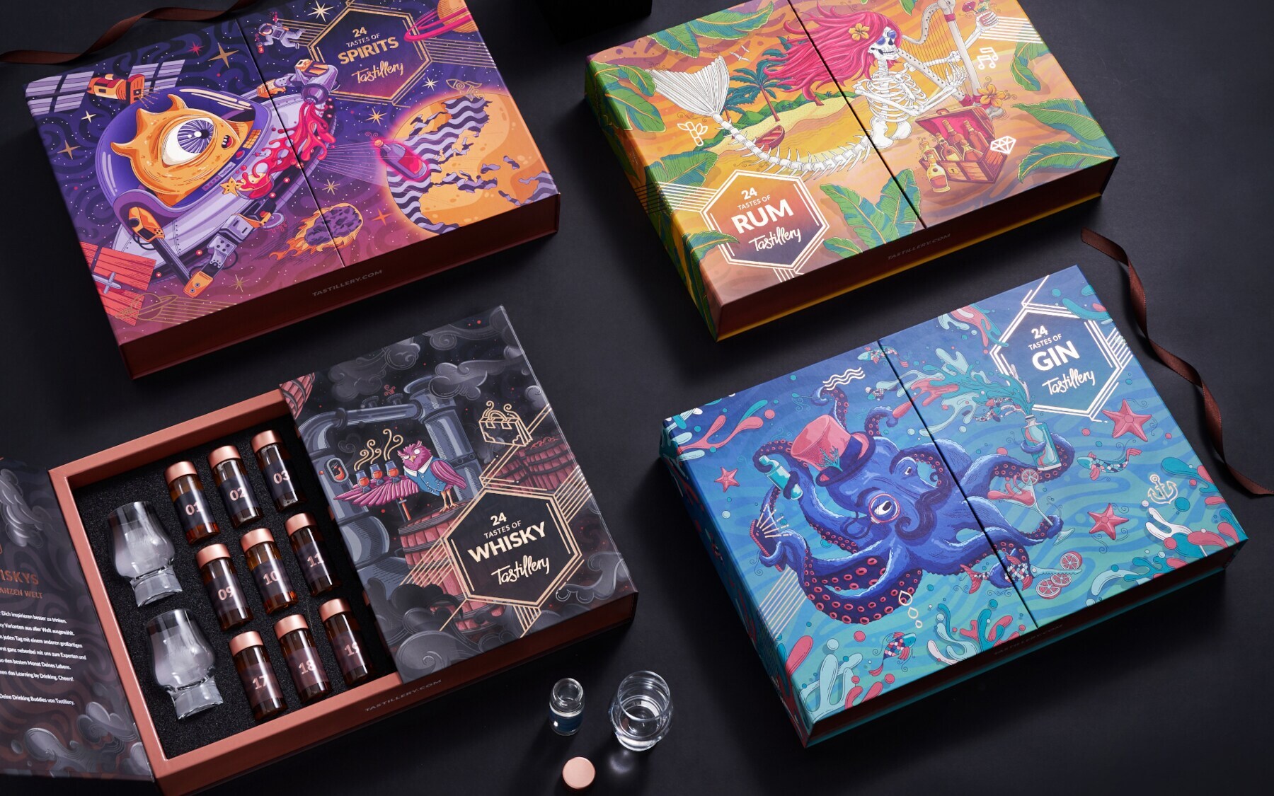 Vier künstlerisch gestaltete Adventskalender, eine geöffnete Box enthält kleine Gläser und Whisky-Shots