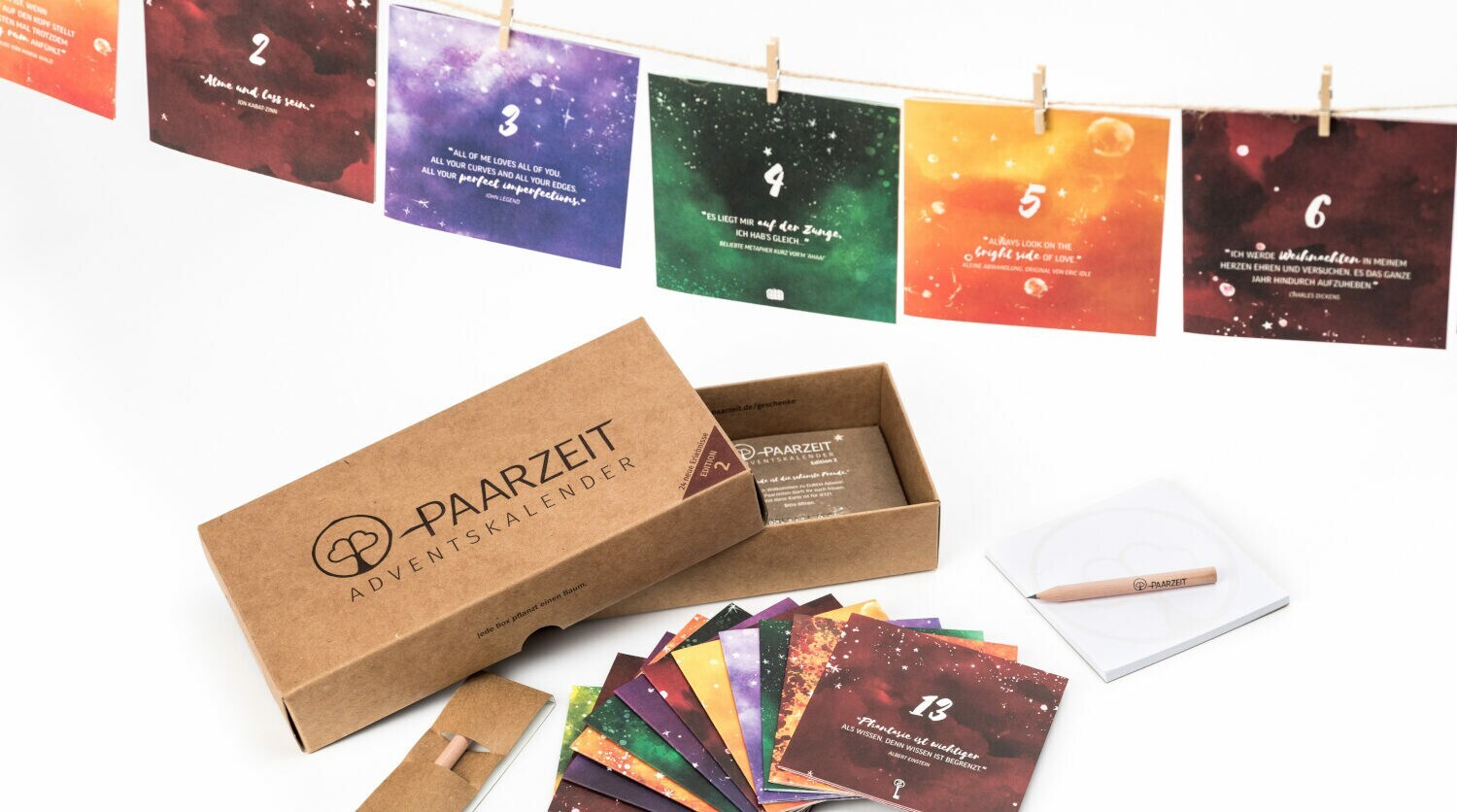 Bunte beschrieben Karten hängen an einer Schnur, daneben ein kleiner Karton mit weiteren Karten.