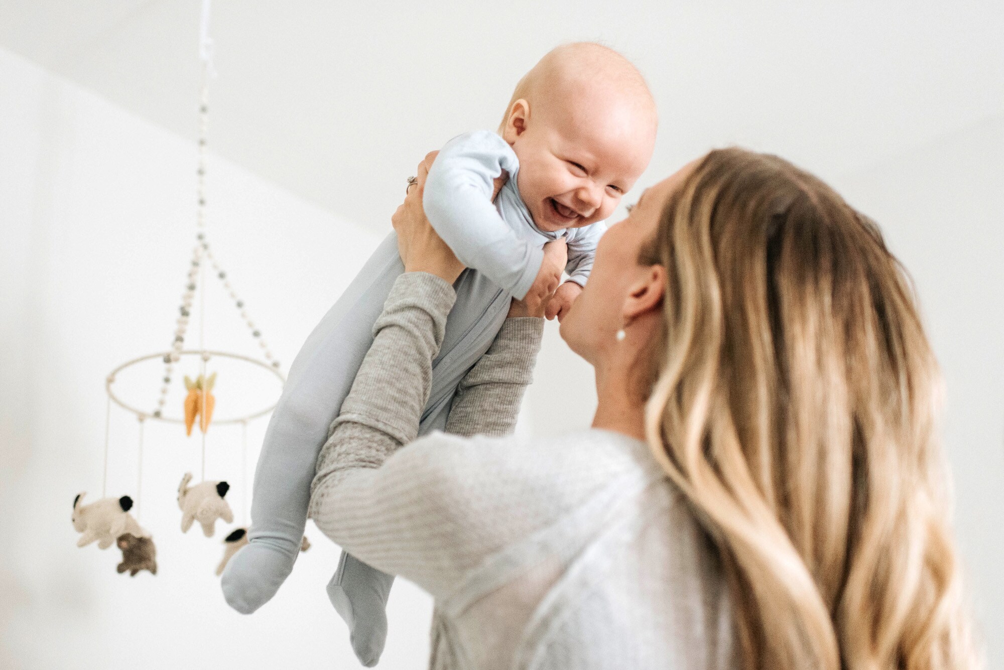 Frau hebt lachendes Baby in die Luft