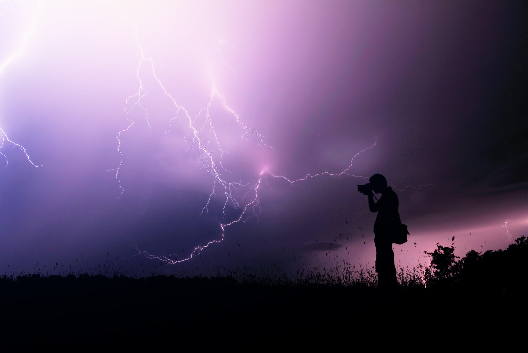 Ein Mann fotografiert ein Gewitter.
