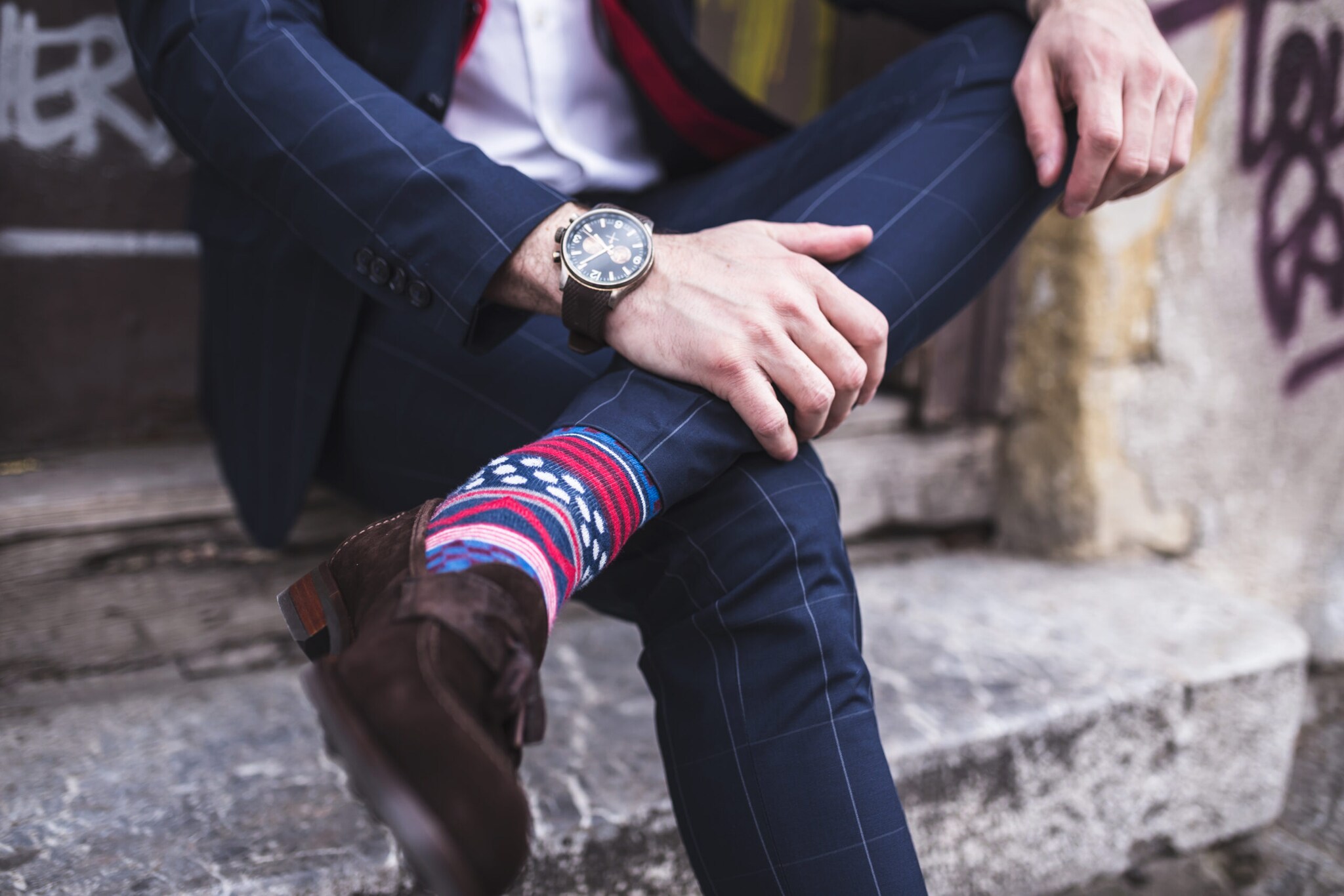 Ein Mann trägt bunt gemusterte Socken zu einem karierten Anzug.