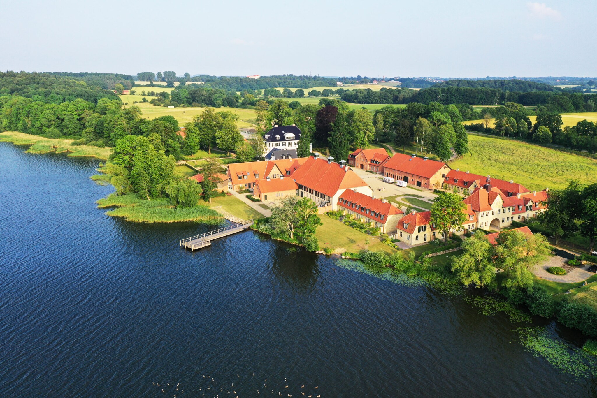 Blick von oben auf ein Gut mit Herrenhaus an einem See Blick von oben auf ein Gut mit Herrenhaus an einem See