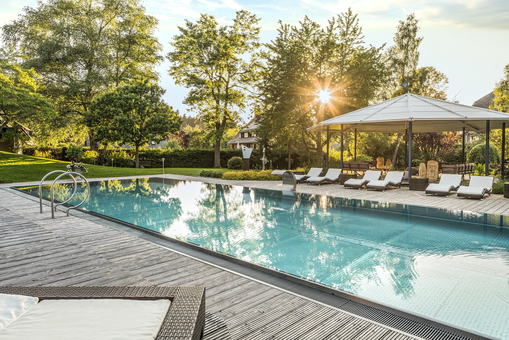 Elegante Terrasse mit Außenpool und Liegestühlen in begrünter Umgebung Elegante Terrasse mit Außenpool und Liegestühlen in begrünter Umgebung