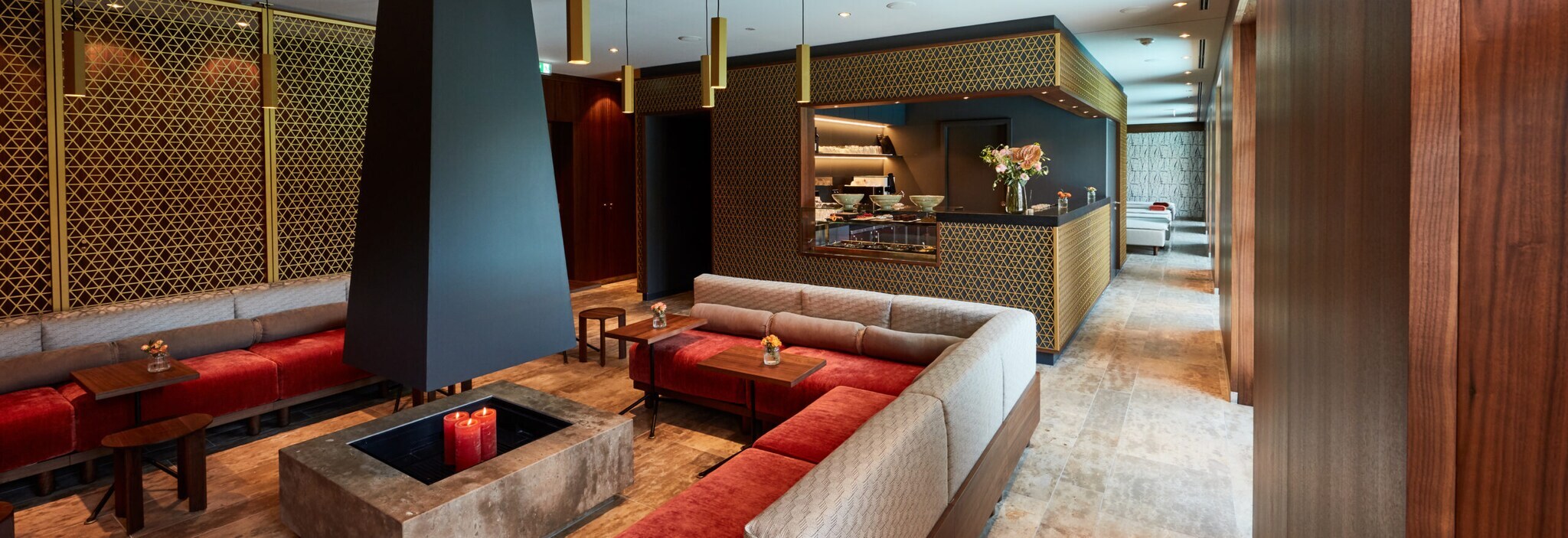 Eine Sitzecke um eine Feuerstelle, im Hintergrund eine Bar