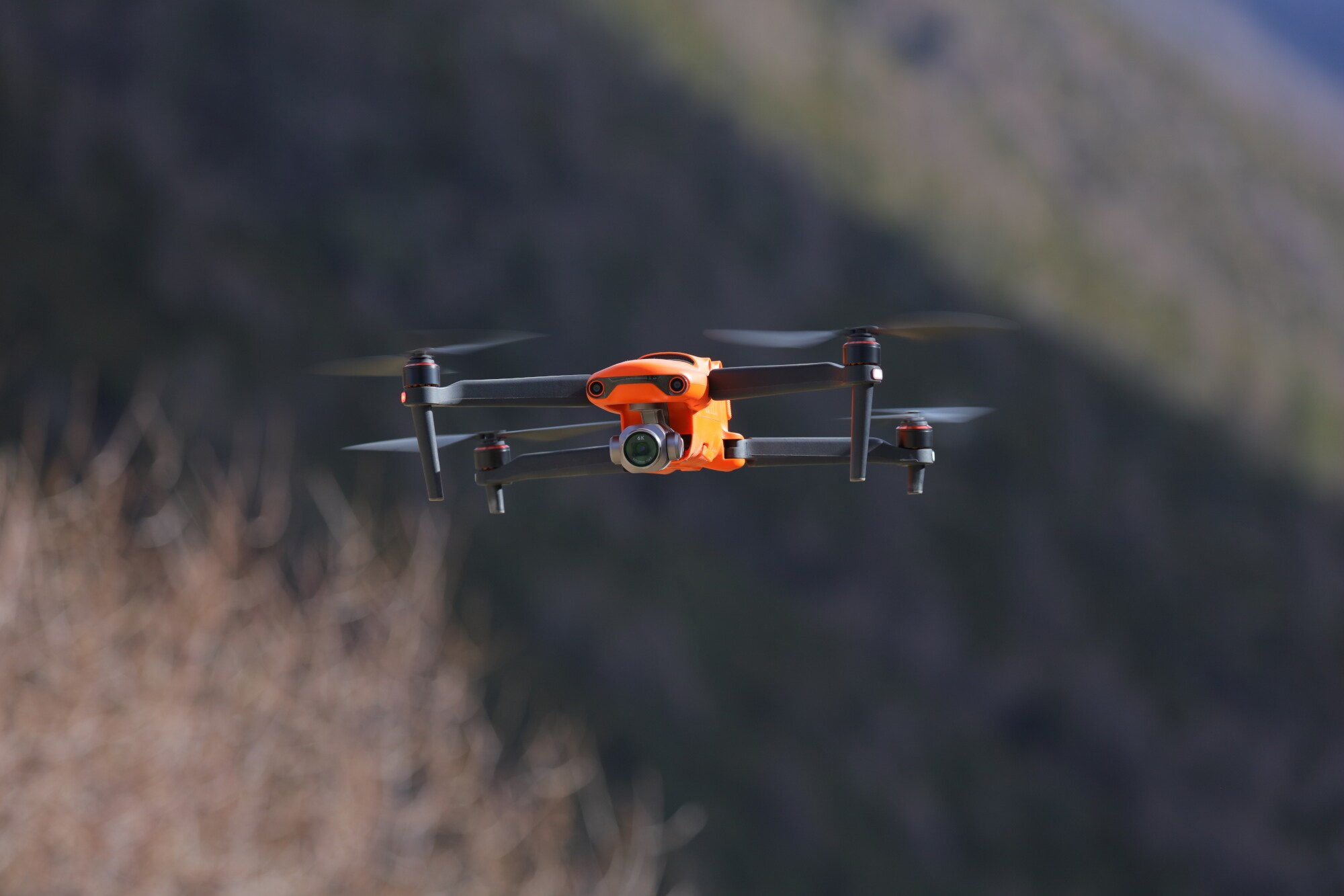 Eine orange-schwarze Kameradrohne in der Luft Eine orange-schwarze Kameradrohne in der Luft