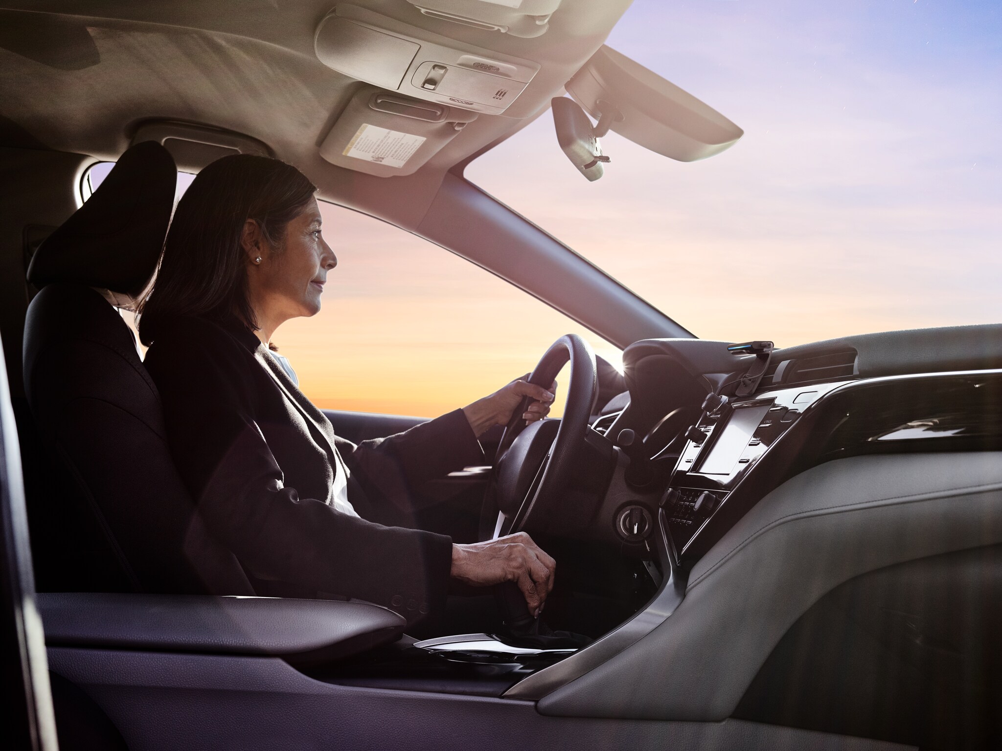 Eine Frau steuert einen PKW, in dem Echo Auto montiert ist.