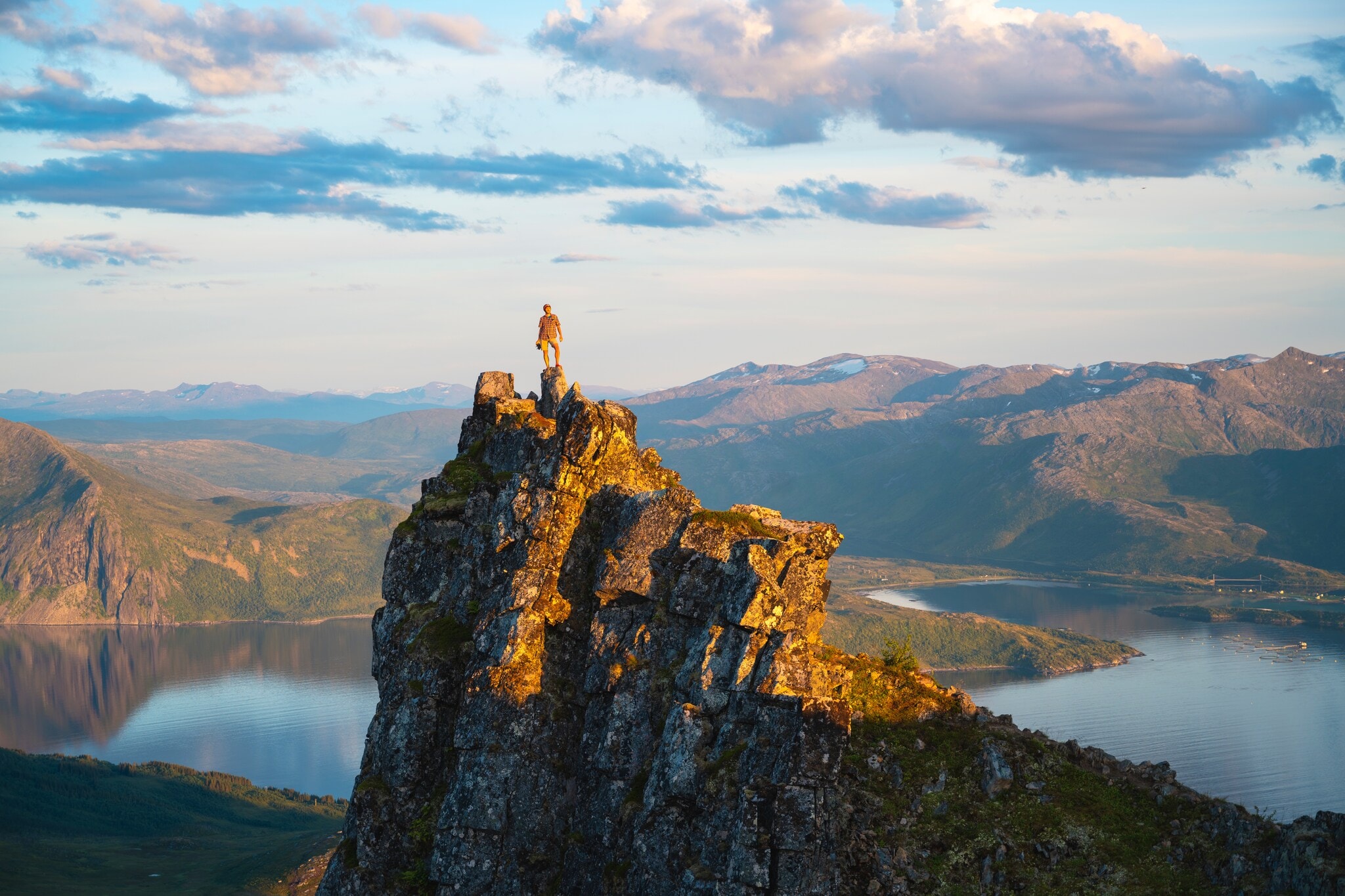 Eine Wanderin auf einem Felsen an einem Fjord. Eine Wanderin auf einem Felsen an einem Fjord.