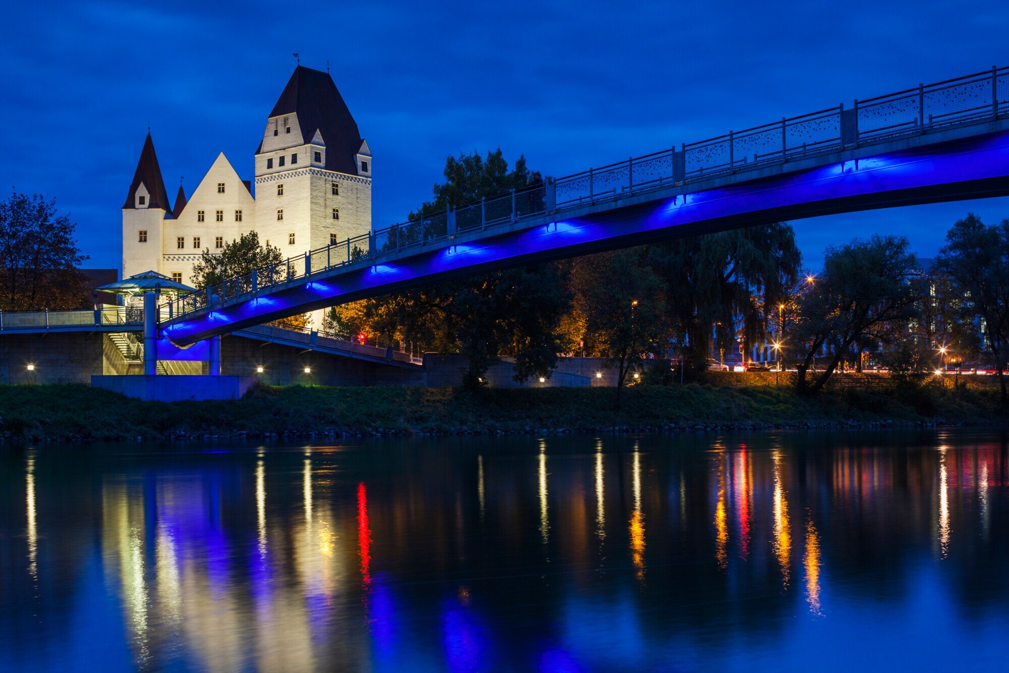 Das beleuchtete Neue Schloss in Ingolstadt bei Nacht, im Vordergrund führt eine Brücke über die Donau Das beleuchtete Neue Schloss in Ingolstadt bei Nacht, im Vordergrund führt eine Brücke über die Donau