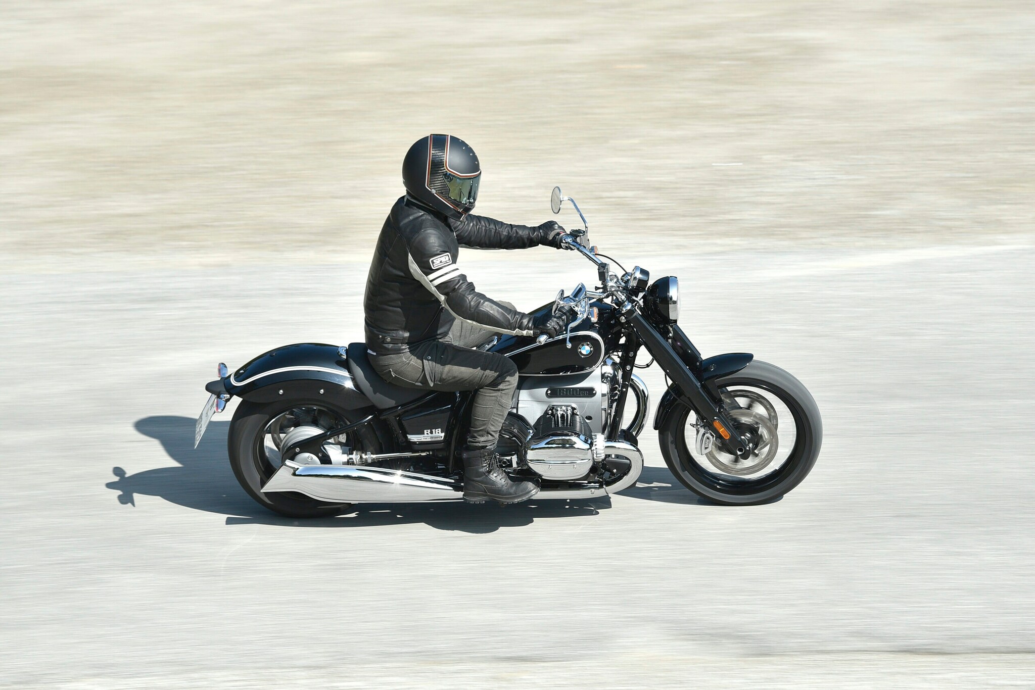 Ein schwarzes Motorrad vom Typ BMW R 18 mit schwarz gekleidetem Fahrer