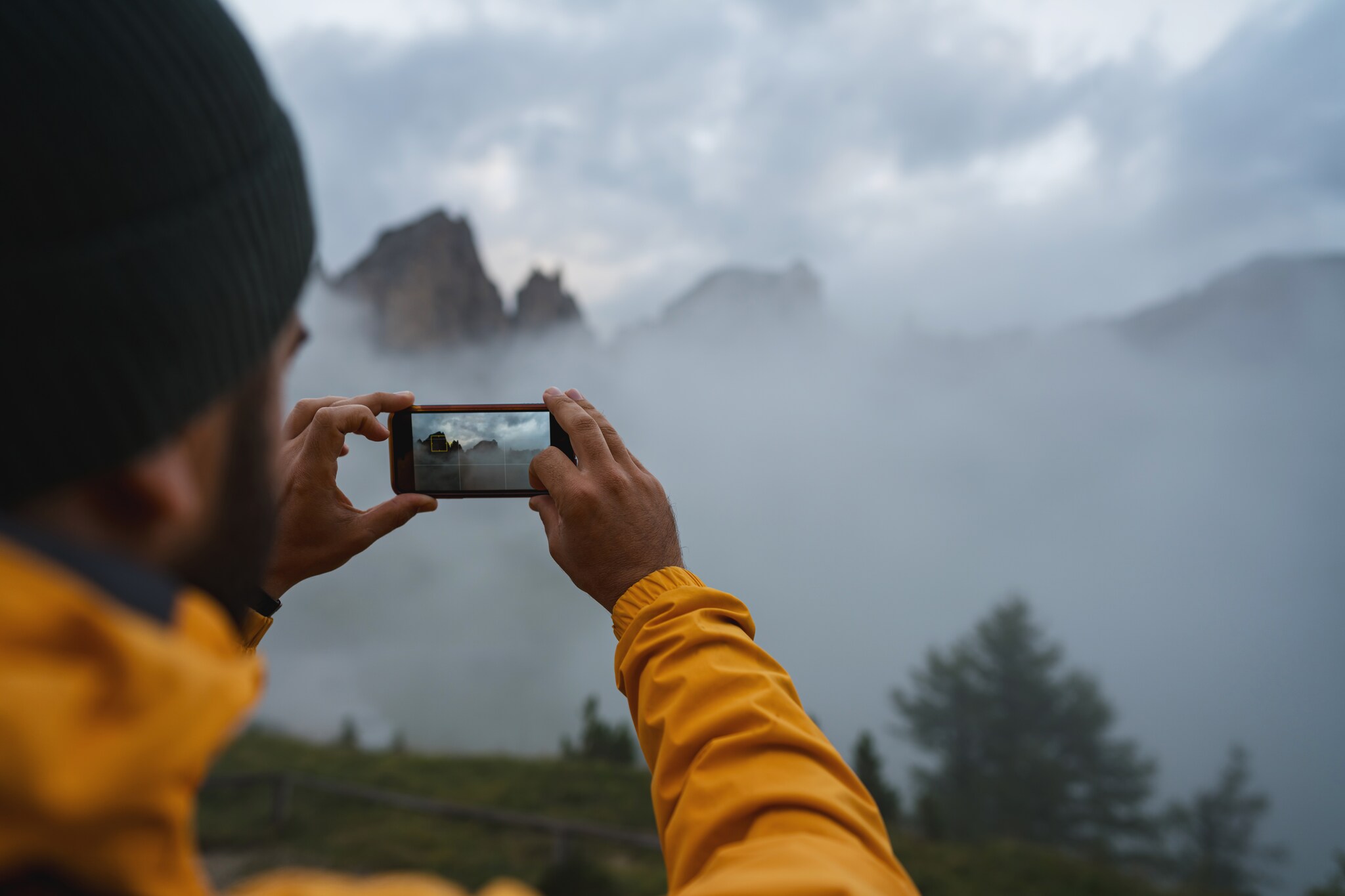Ein Mann fotografiert mit seinem Smartphone.