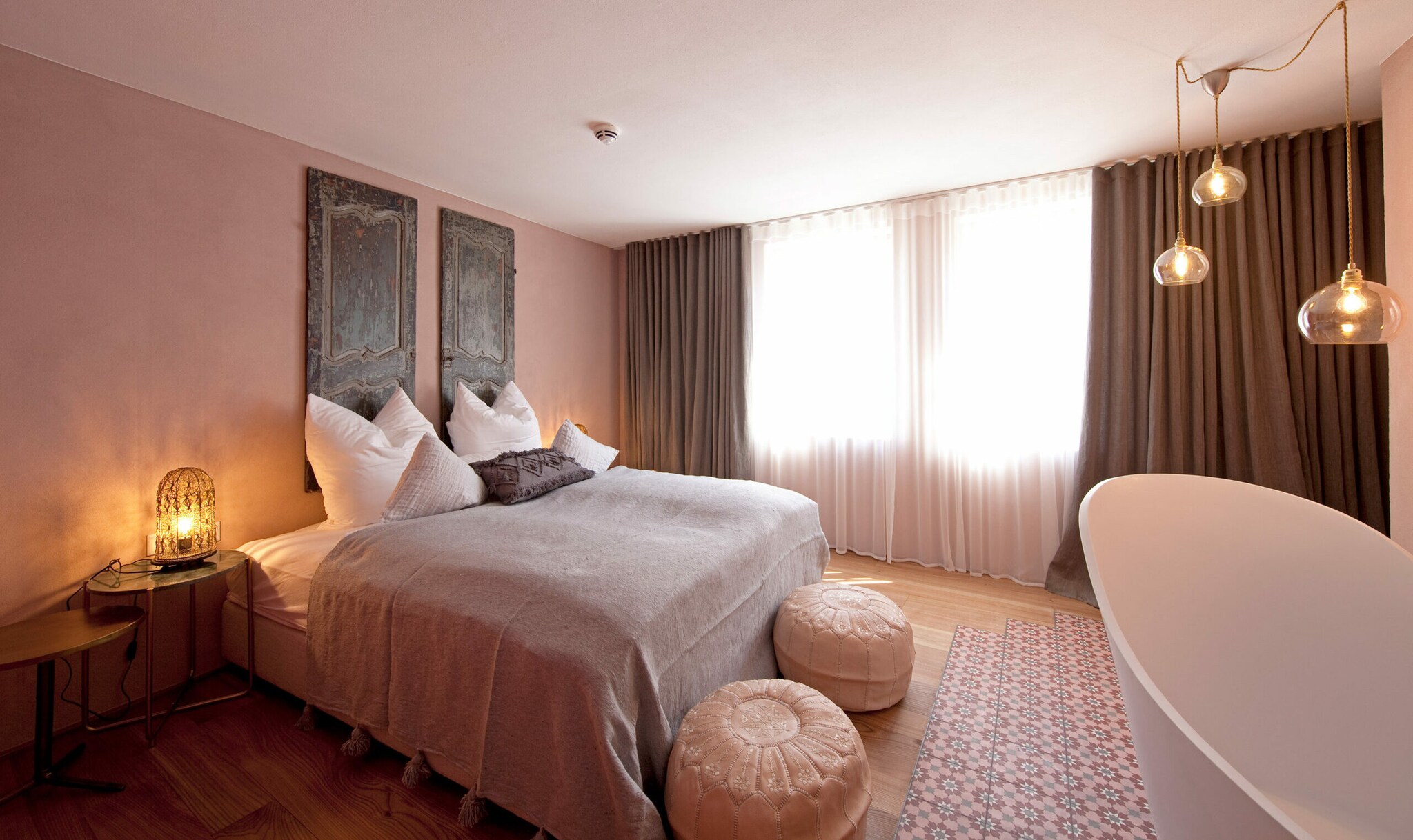 Hotelzimmer in Pastellfarben mit Doppelbett und Badewanne Hotelzimmer in Pastellfarben mit Doppelbett und Badewanne