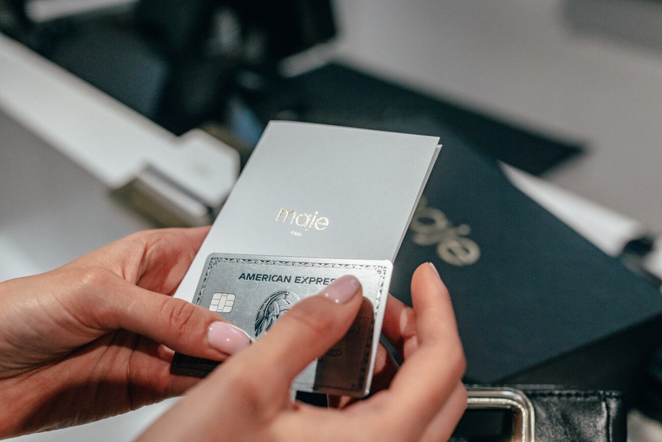 Frauenhände halten eine Platinum Kreditkarte sowie einen verdeckten Einkaufsbeleg Frauenhände halten eine Platinum Kreditkarte sowie einen verdeckten Einkaufsbeleg