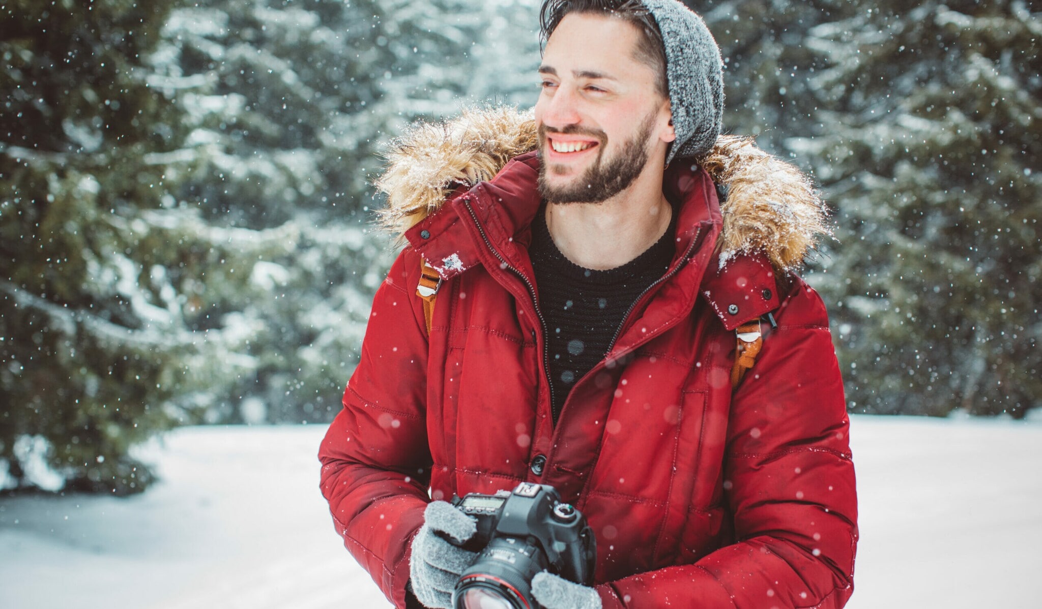 Ein Mann mit Kamera lächelt im Schnee. Ein Mann mit Kamera lächelt im Schnee.