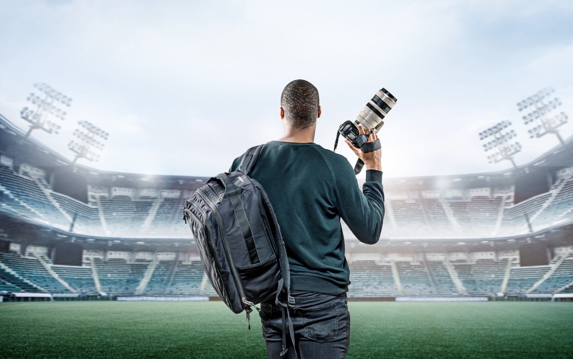 Mann im Stadion mit Kamera und Teleobjektiv Mann im Stadion mit Kamera und Teleobjektiv