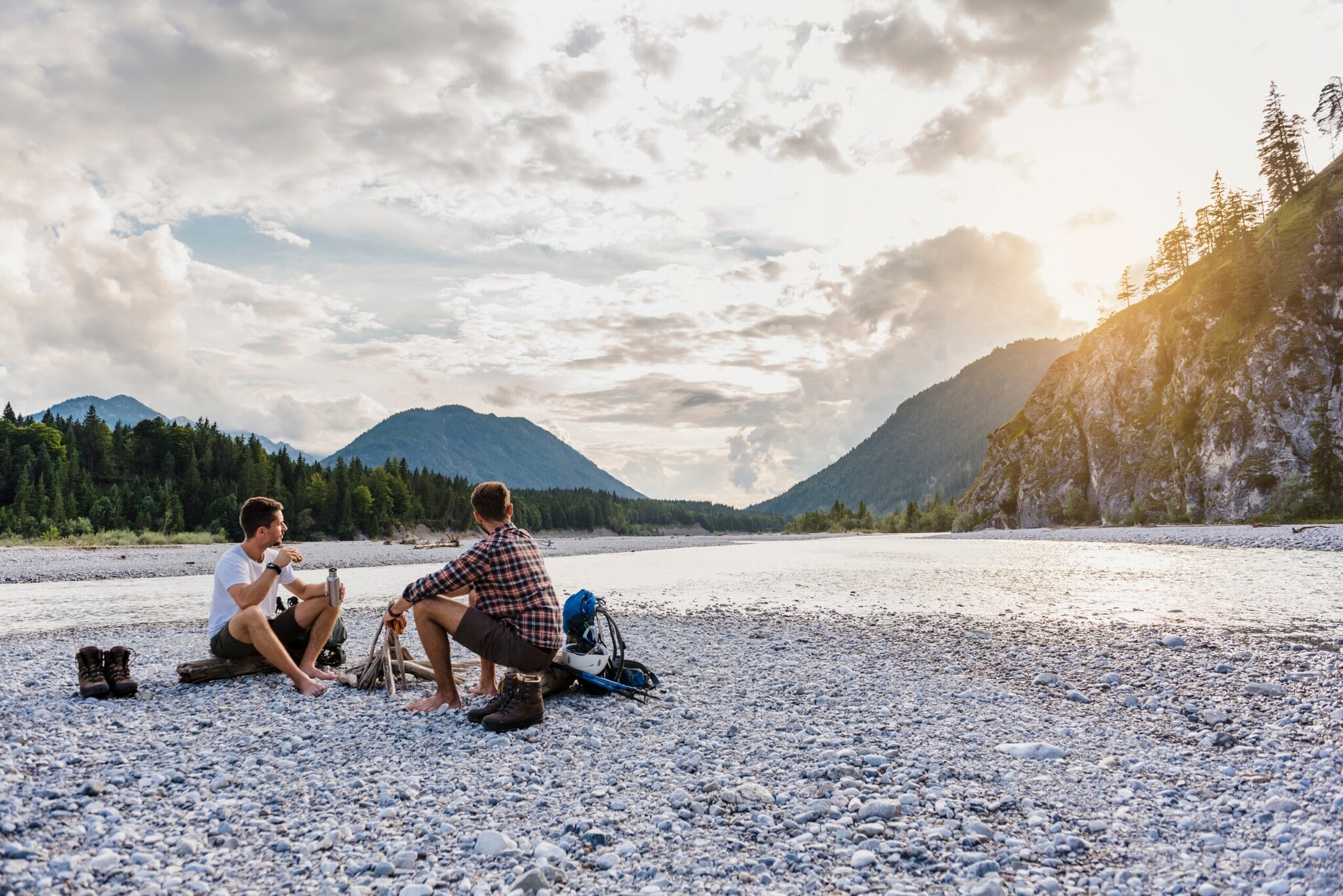 Zwei Männer sitzen vor einer einsamen Bergkulisse Zwei Männer sitzen vor einer einsamen Bergkulisse