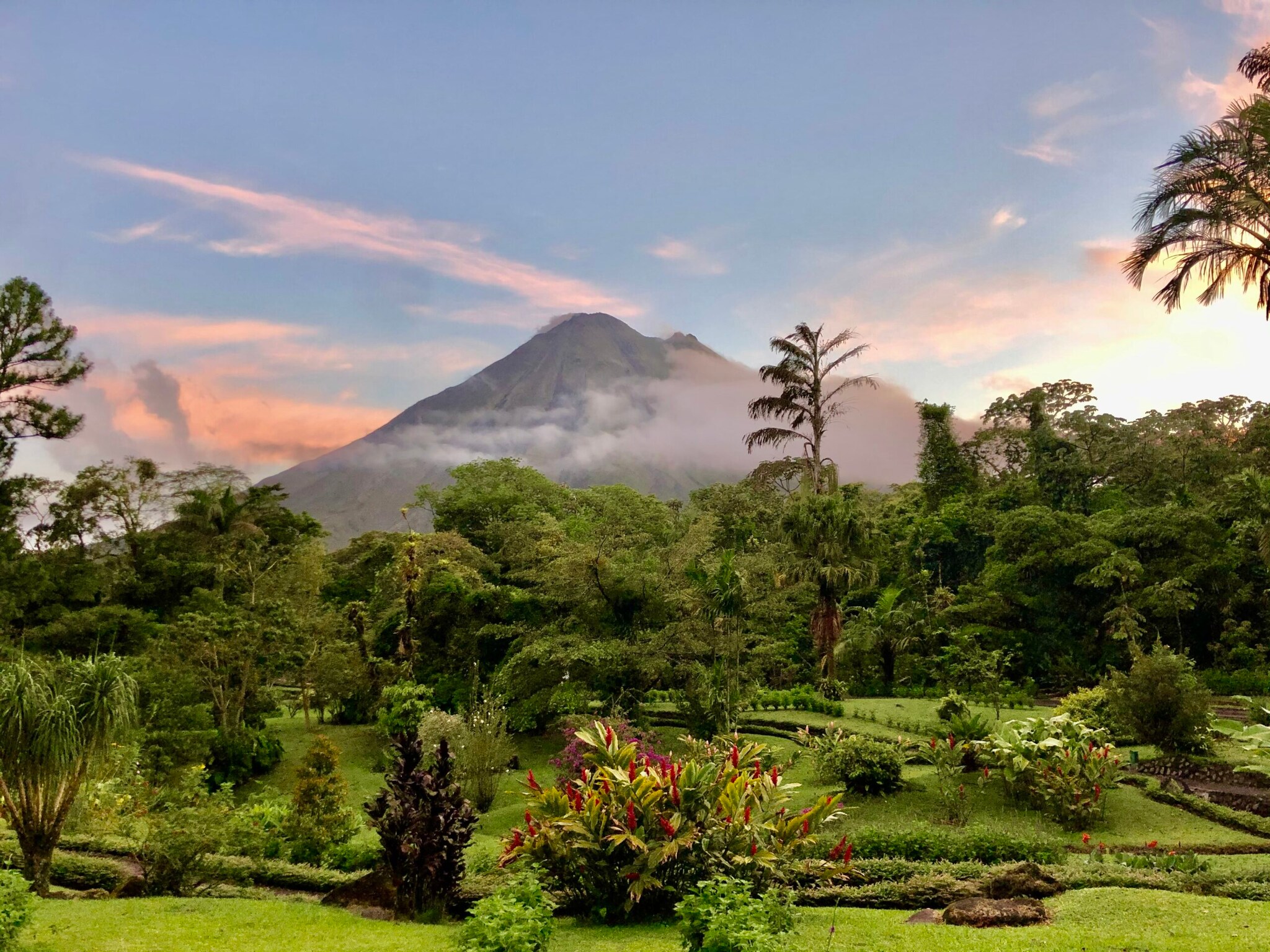 Im Hintergrund der Volcán Arenal, im Vordergrund eine grüne Landschaft