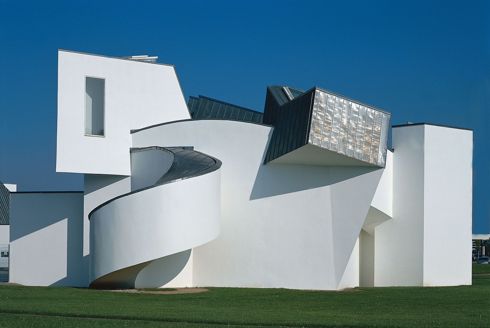 Ein weißes, architektonisch verspieltes Gebäude auf einer grünen Wiese. Ein weißes, architektonisch verspieltes Gebäude auf einer grünen Wiese.