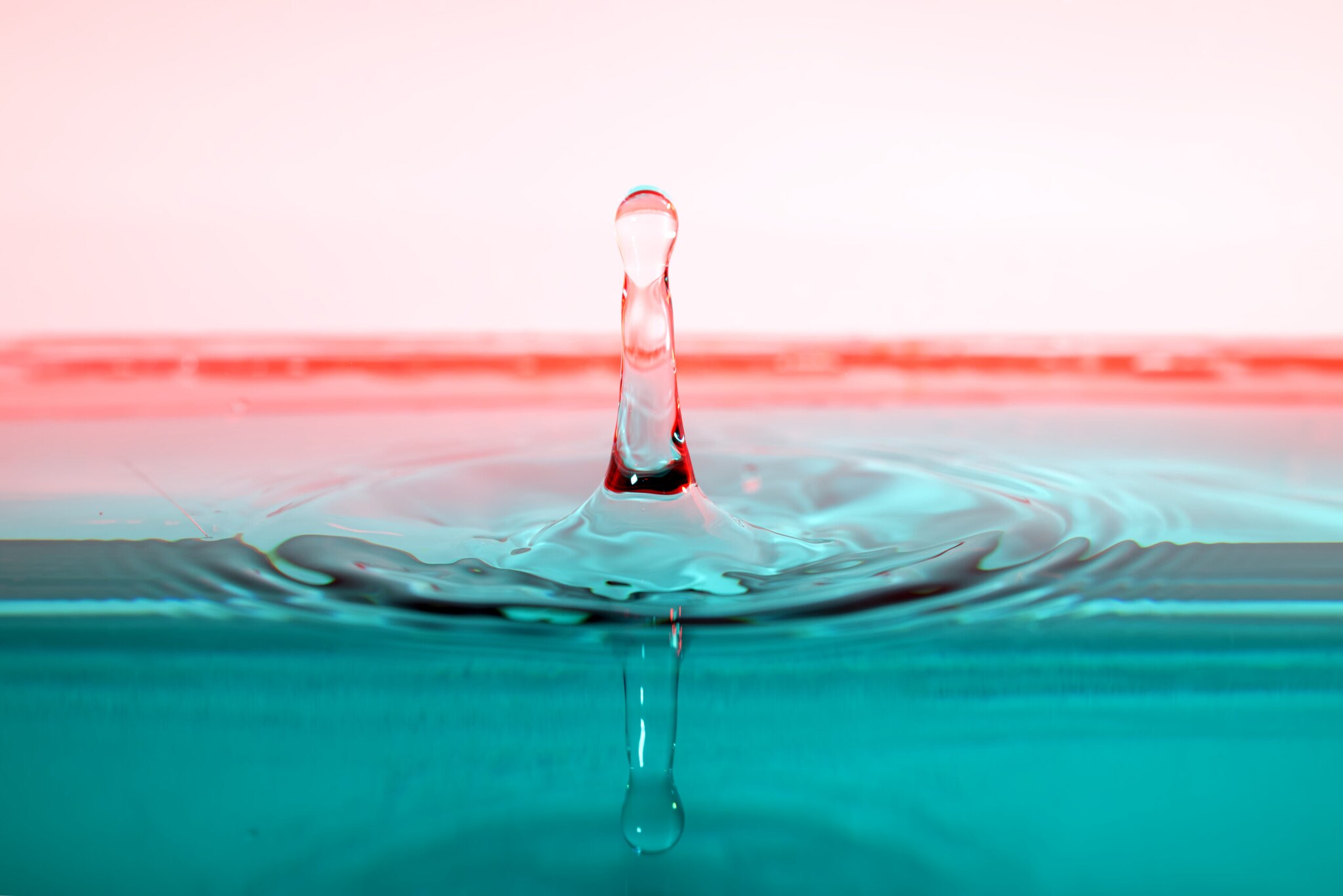 Ein Wassertropfen spiegelt sich in der Wasseroberfläche.