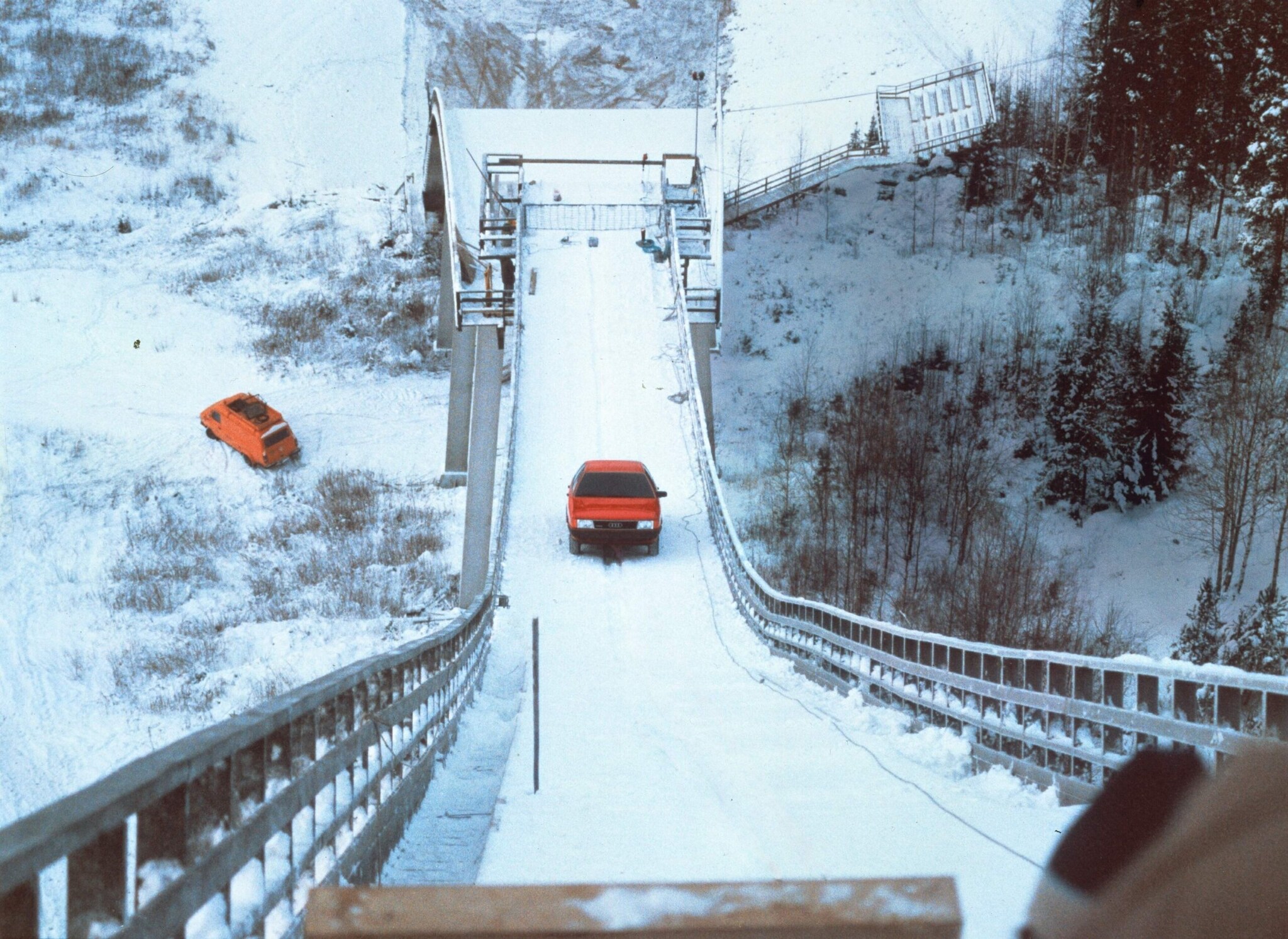 Ein Audi 100 Quattro fährt eine Sprungschanze hinauf.