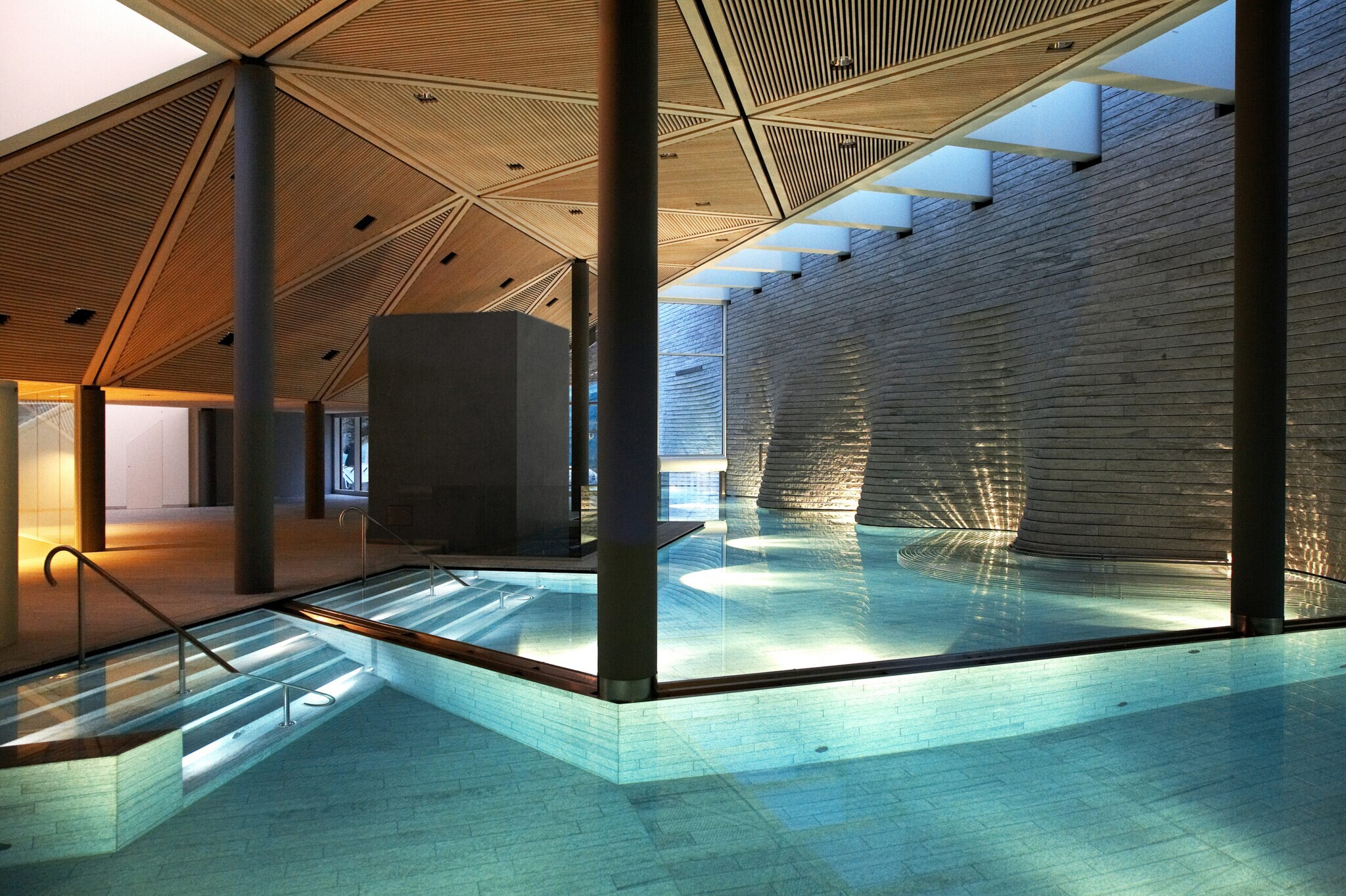 Überdachter, beleuchteter Pool in moderner Architektur mit Granit-Wänden