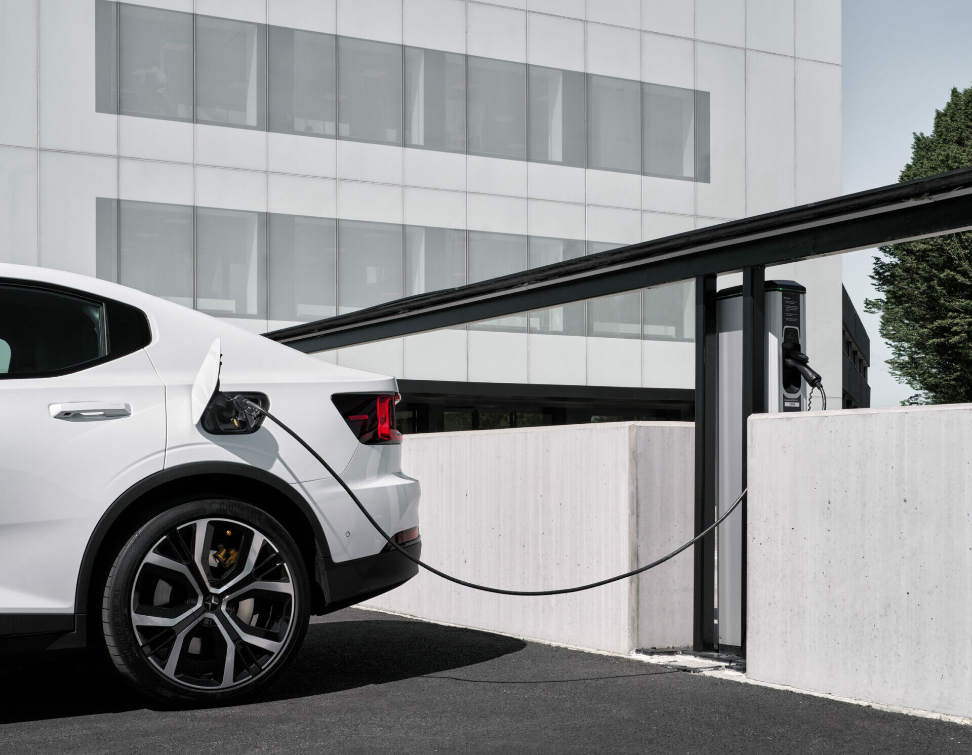 Ein weißes E-Auto an einer Ladestation. Ein weißes E-Auto an einer Ladestation.