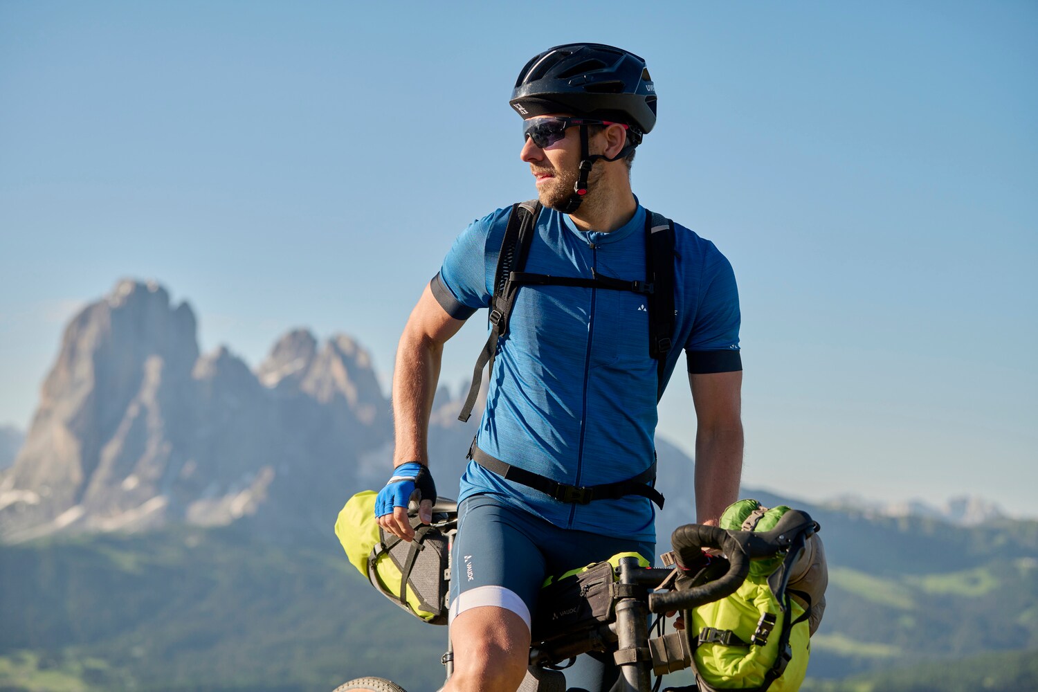 Mann in Sportoutfit auf dem Rennrad, im Hintergrund Berge