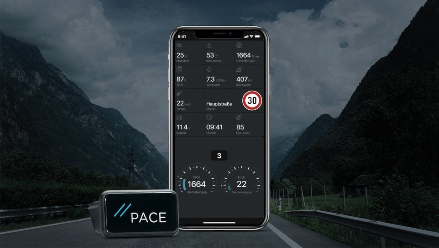 Ein OBD-2-Modul neben einem Smartphone, im Hintergrund eine Autobahn, die durch Berge führt Ein OBD-2-Modul neben einem Smartphone, im Hintergrund eine Autobahn, die durch Berge führt