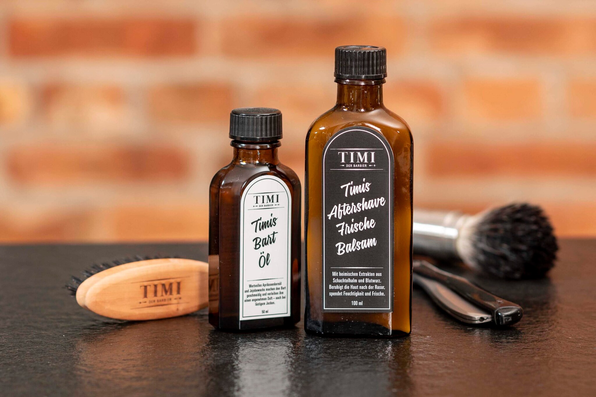 Zwei Pflegeprodukte in braunen Apotheker-Fläschchen für Männer neben Rasierpinsel, Bürste und einem klassischen Rasiermesser