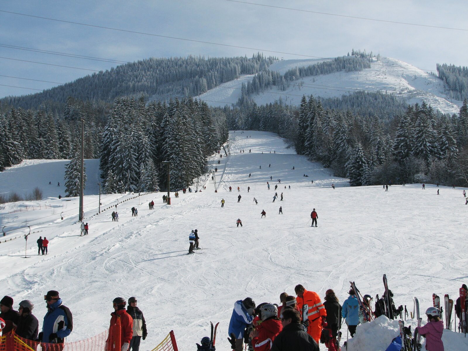 Skifahrer auf einer breiten Piste mit Schlepplift