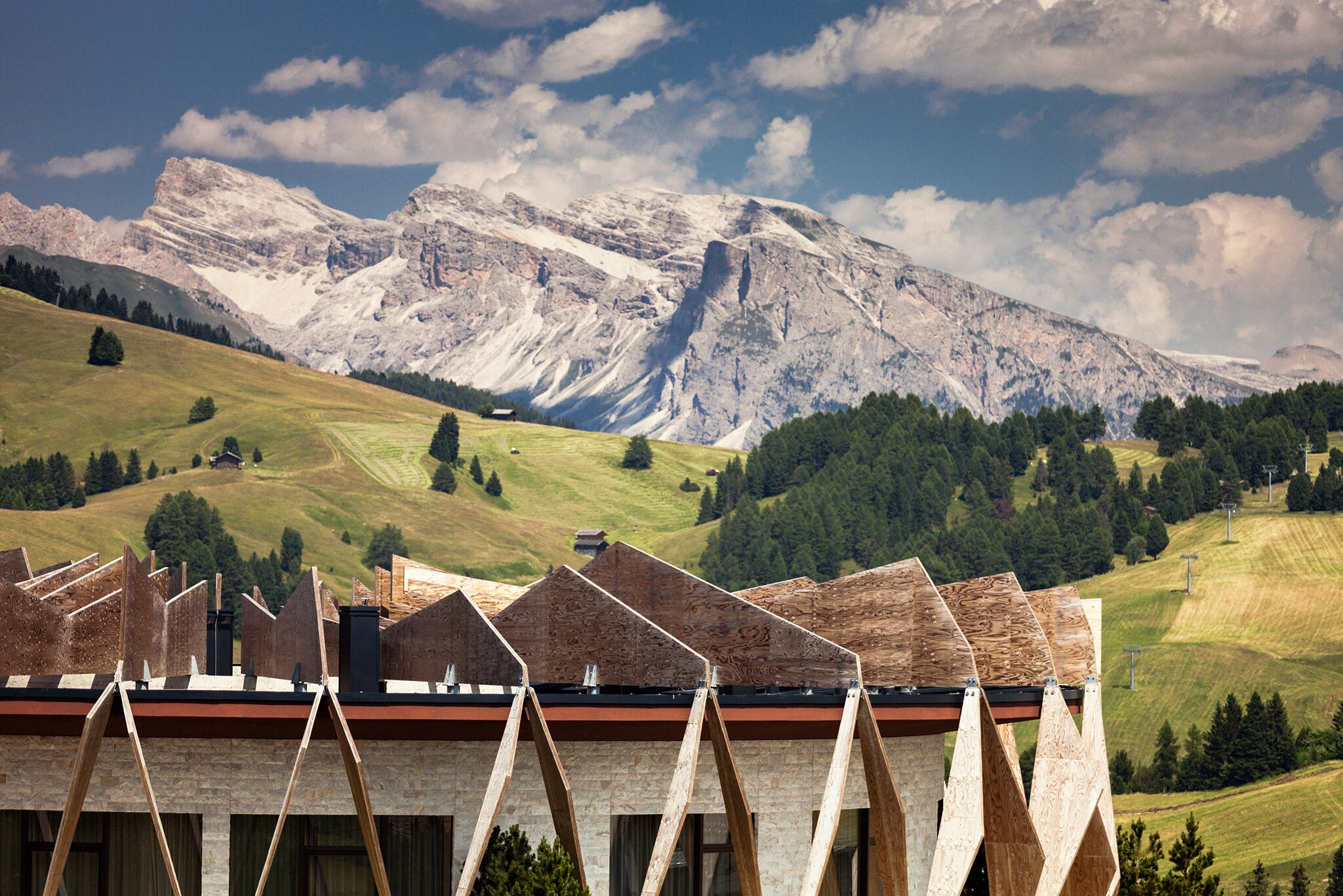 Teil des Chalets vor dem Hintergrund der grünen Al und schneebedeckten Dolomiten