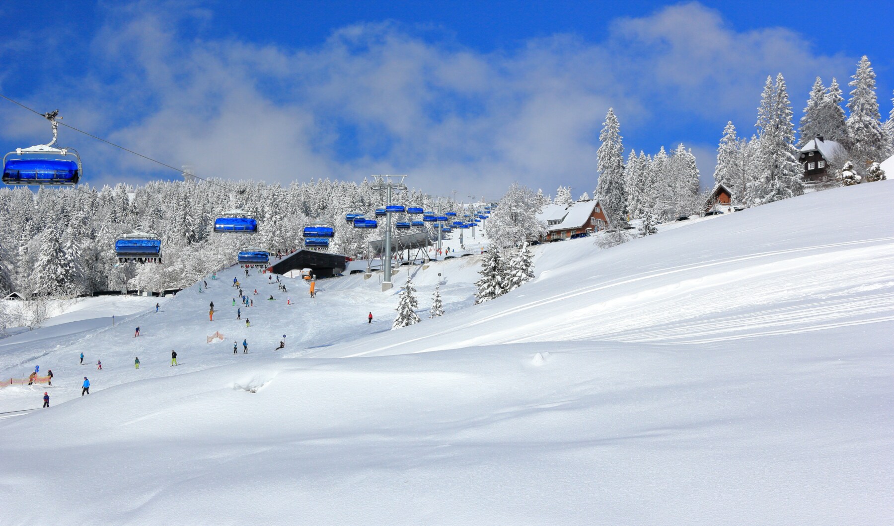 Skigebiet am Feldberg mit Sessellift und Personen auf der Piste