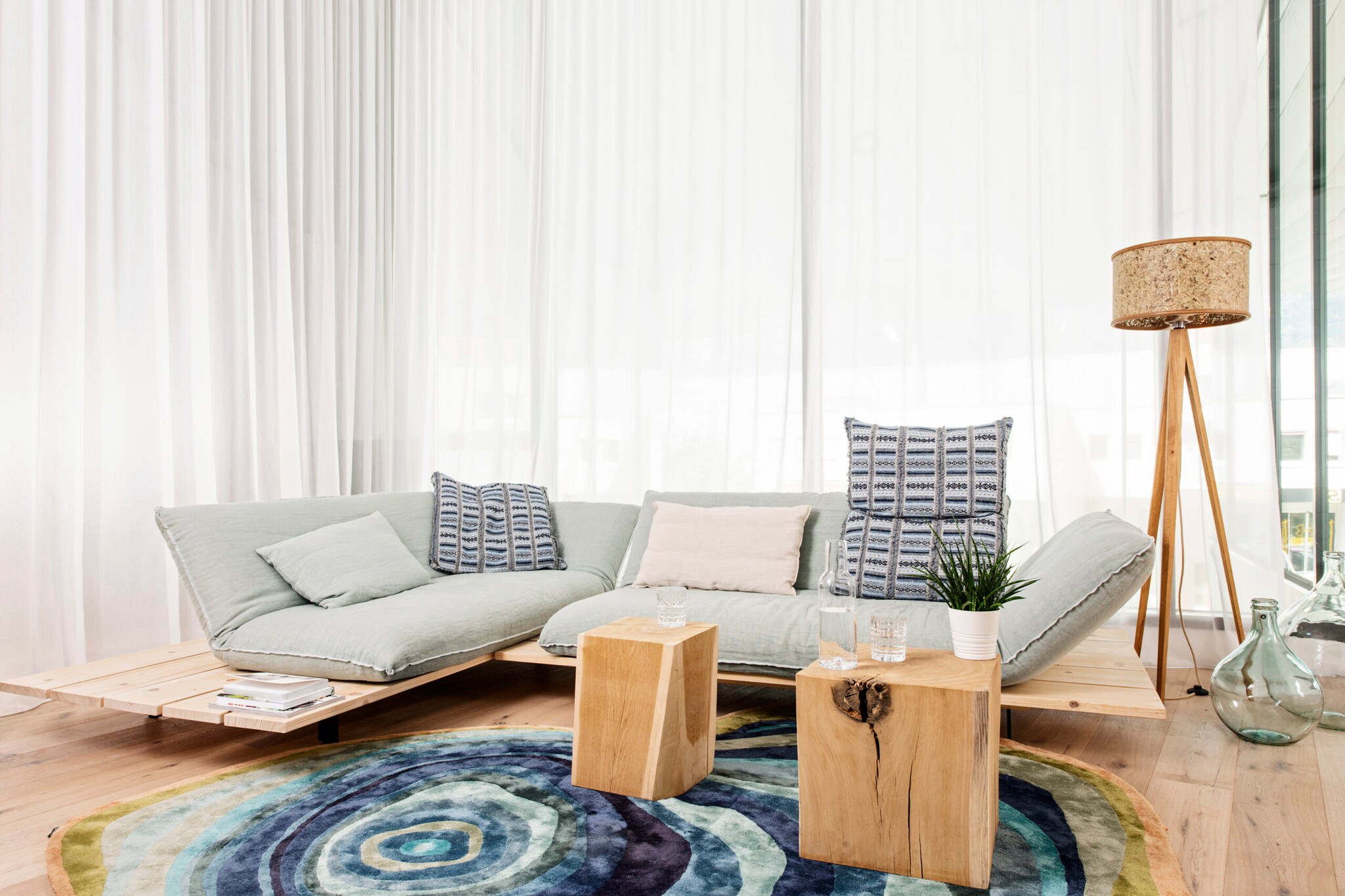 Neben einer Couch im Wohnzimmer steht eine Stehlampe mit einem Lampenschirm aus Heu