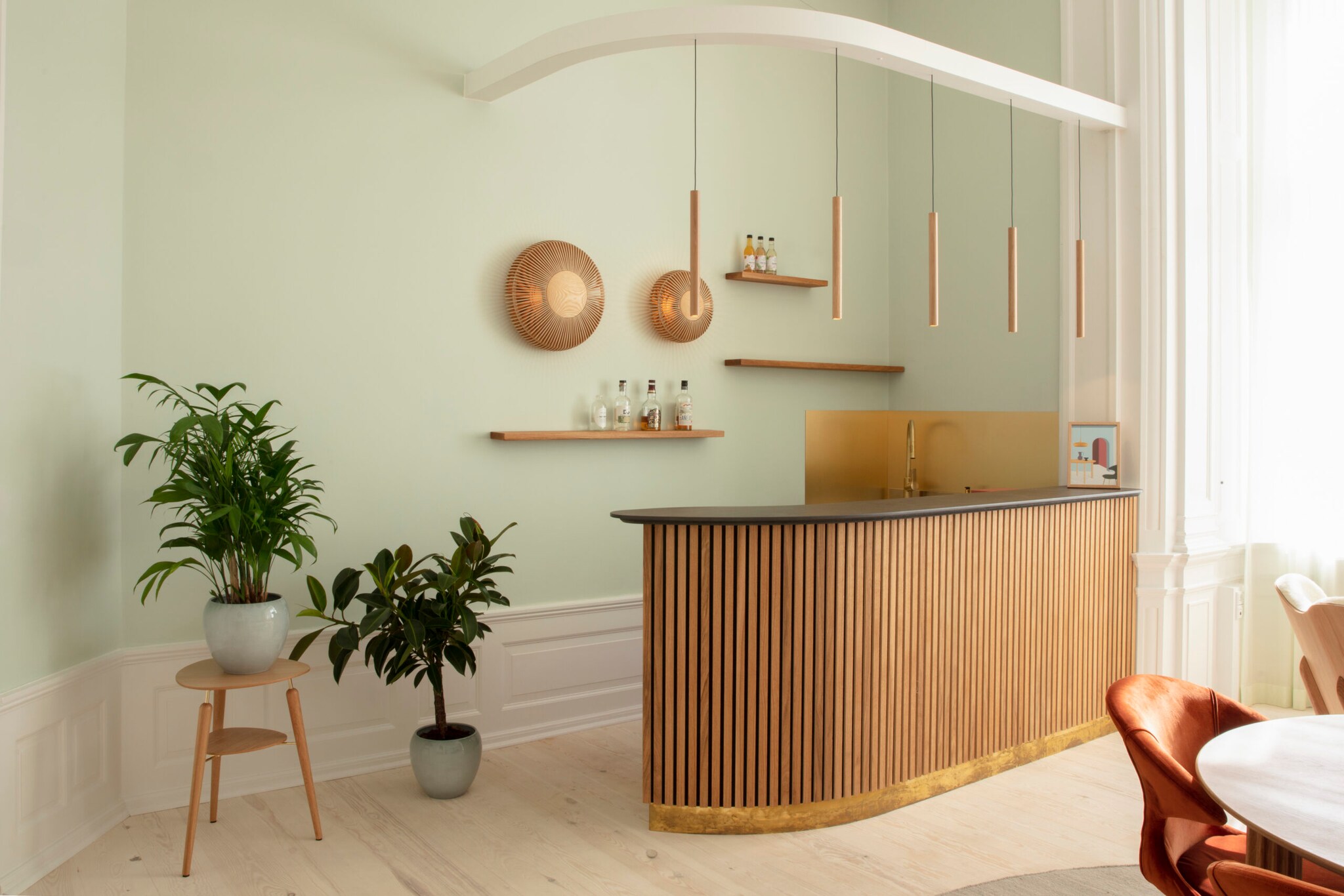 Ein Küchentresen aus Holz und runden Holzlampen an der Wand.