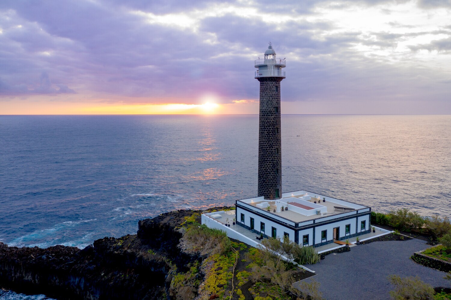 Ein schmaler und eleganter Leuchtturm aus Backsteinen direkt an der Felsküste von La Palma
