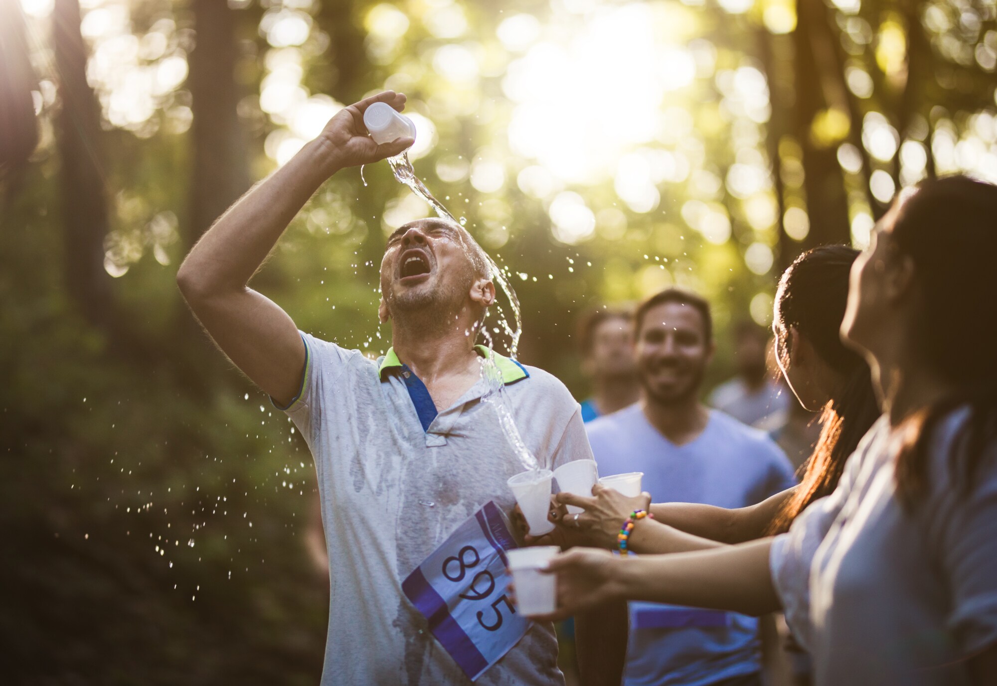 Ein Läufer erfrischt sich mit Wasser Ein Läufer erfrischt sich mit Wasser