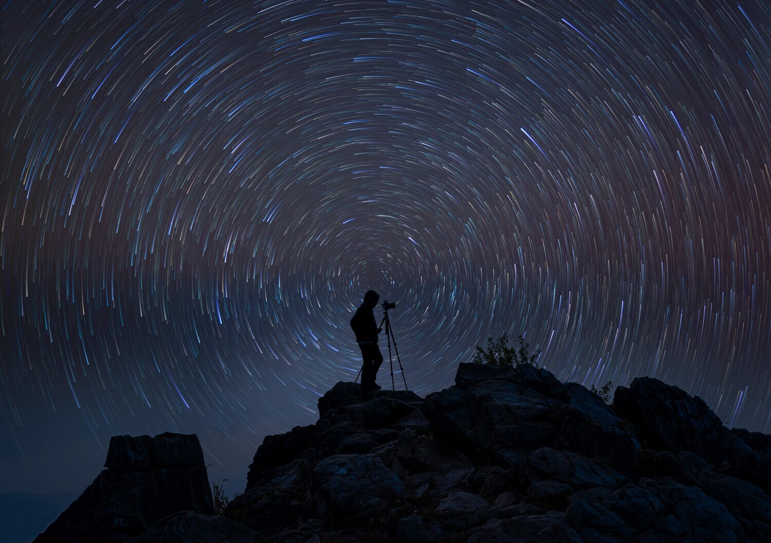 Fotograf mit Stativ in der Dunkelheit