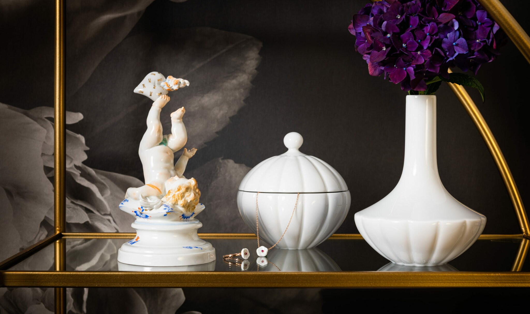 Weißes Porzellangut auf einem gold-gläsernem Regal
