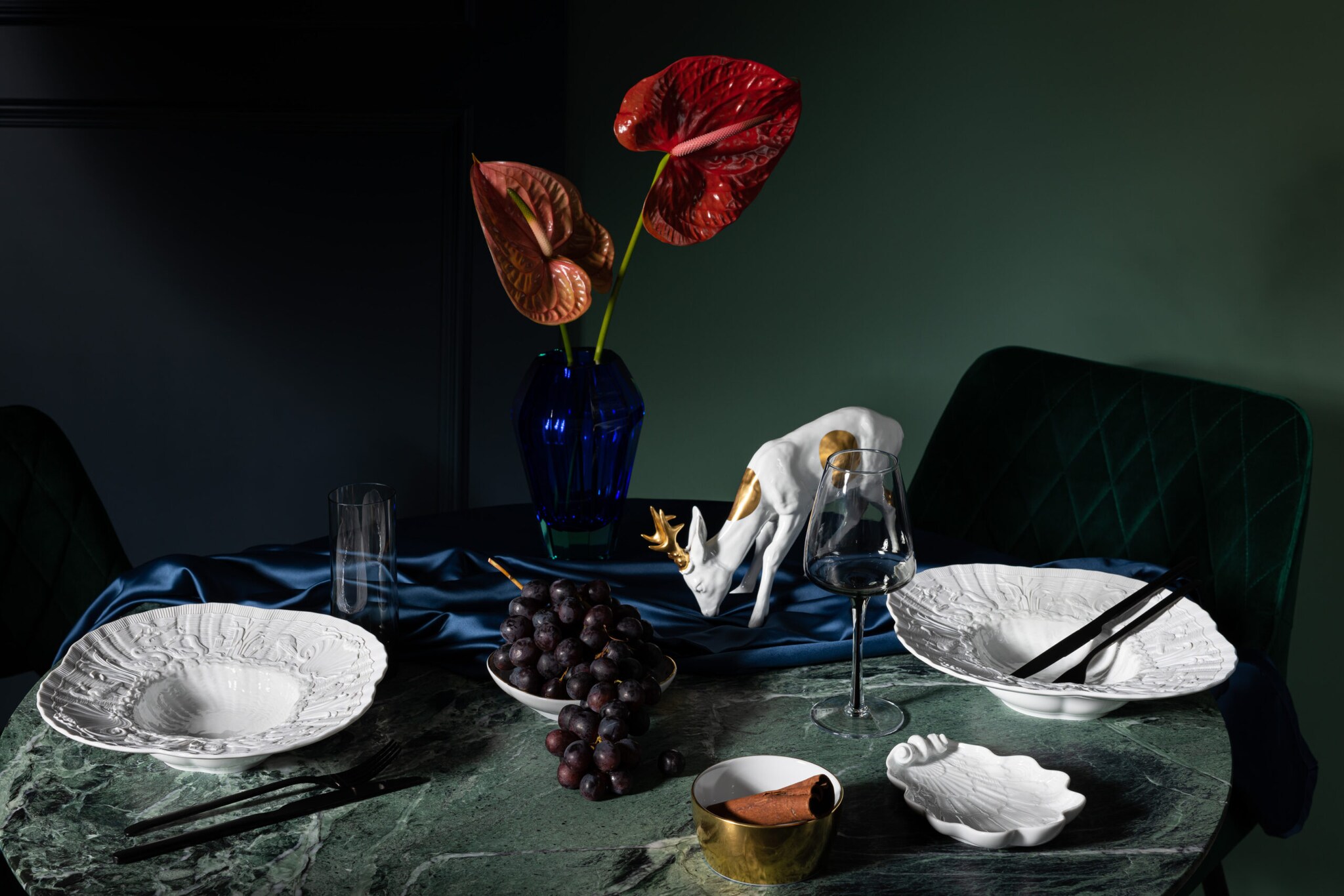 Ein gedeckter Marmortisch mit weißem, opulentem Porzellangeschirr