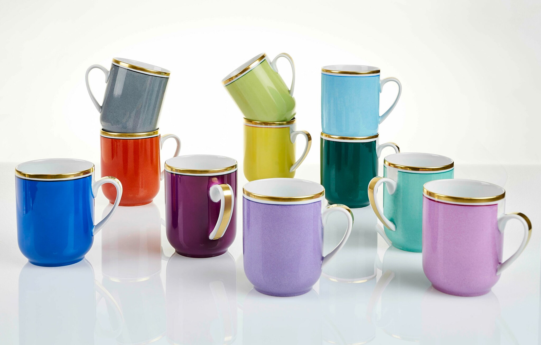 Elf bunte Kaffeebecher mit Goldrand neben- und übereinander