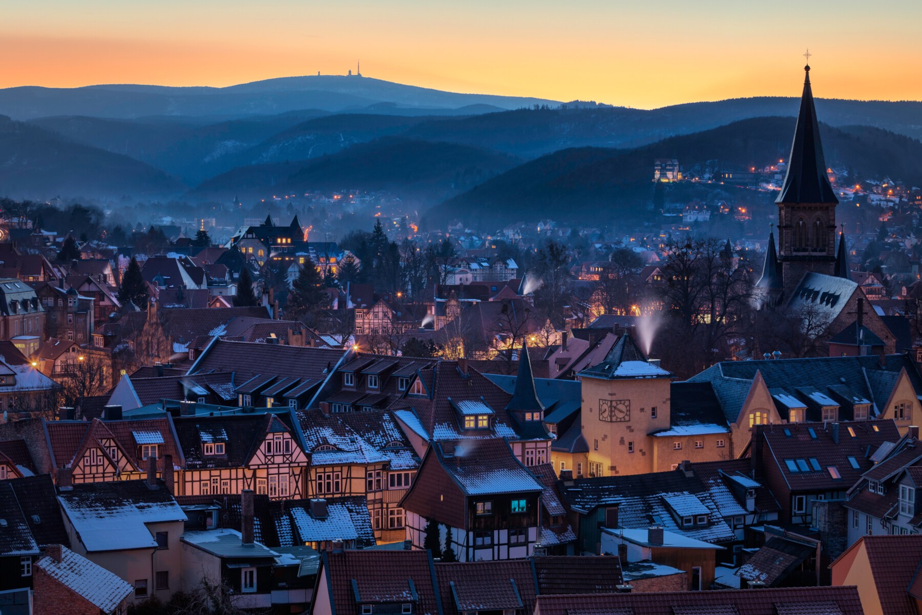 Blick auf eine beleuchtete Fachwerkstadt vor bewaldeten Hügeln Blick auf eine beleuchtete Fachwerkstadt vor bewaldeten Hügeln