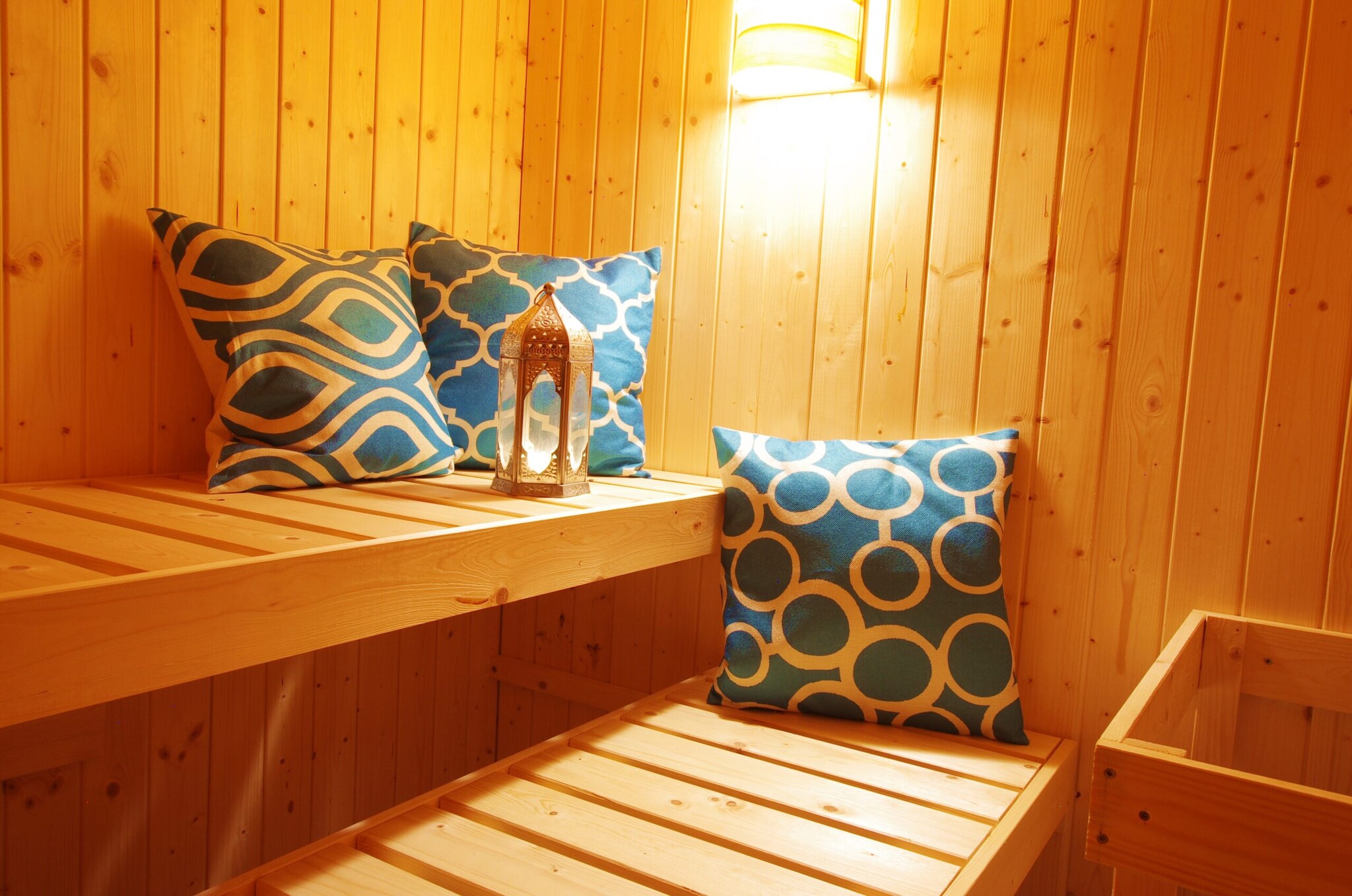 Drei blau gemusterte Kissen in einer Holzsauna