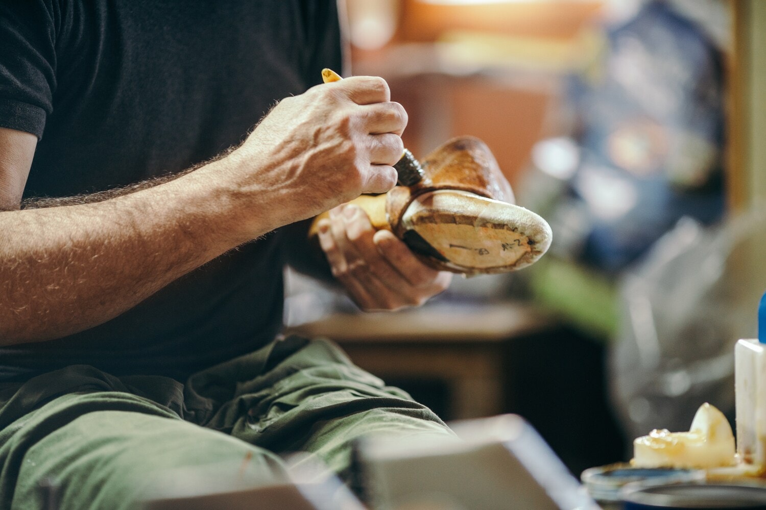 Zwei Hände bearbeiten ein hölzernes Schuh-Negativ Zwei Hände bearbeiten ein hölzernes Schuh-Negativ